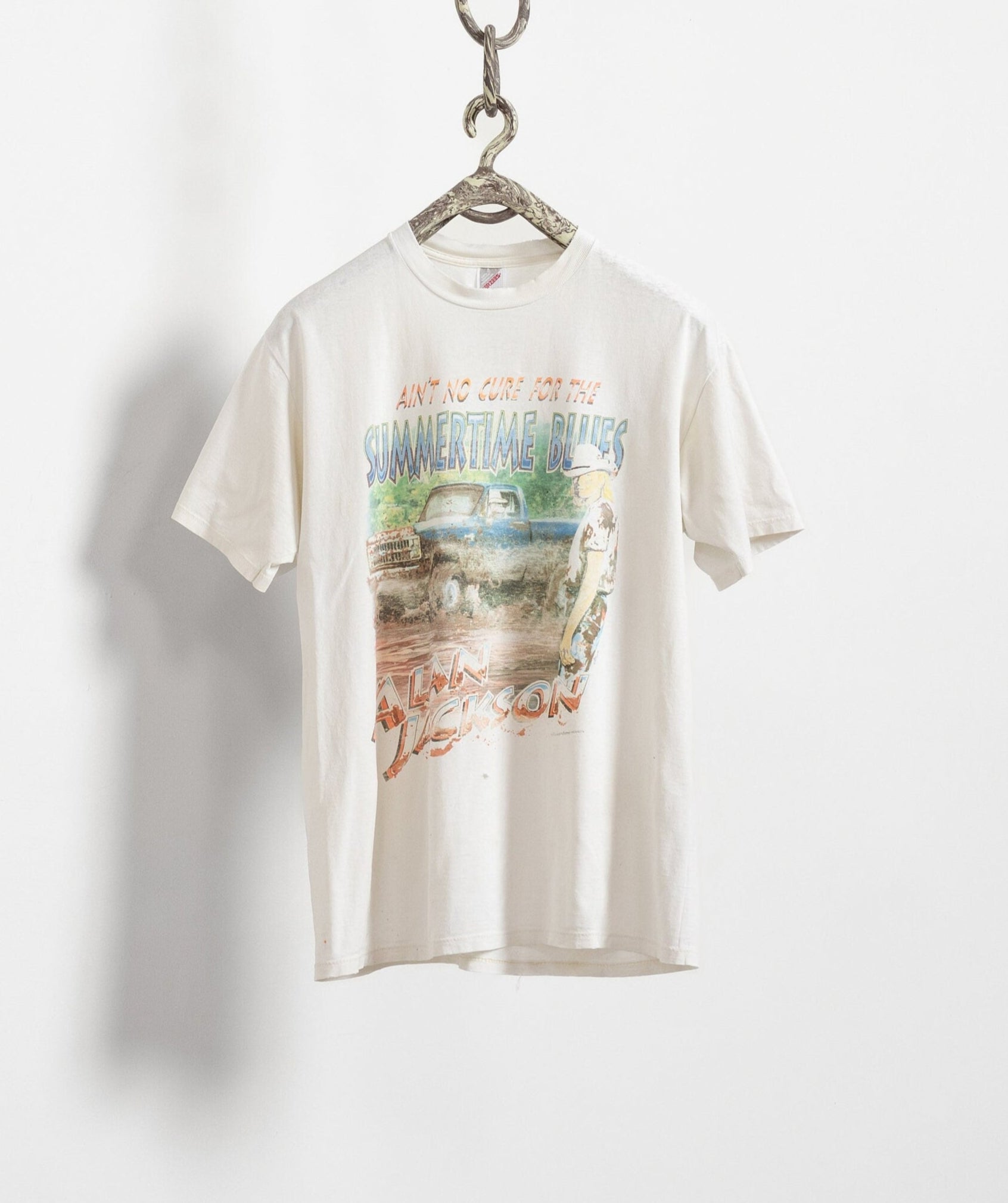 White t-shirt with graphic design on a hanger against a white background