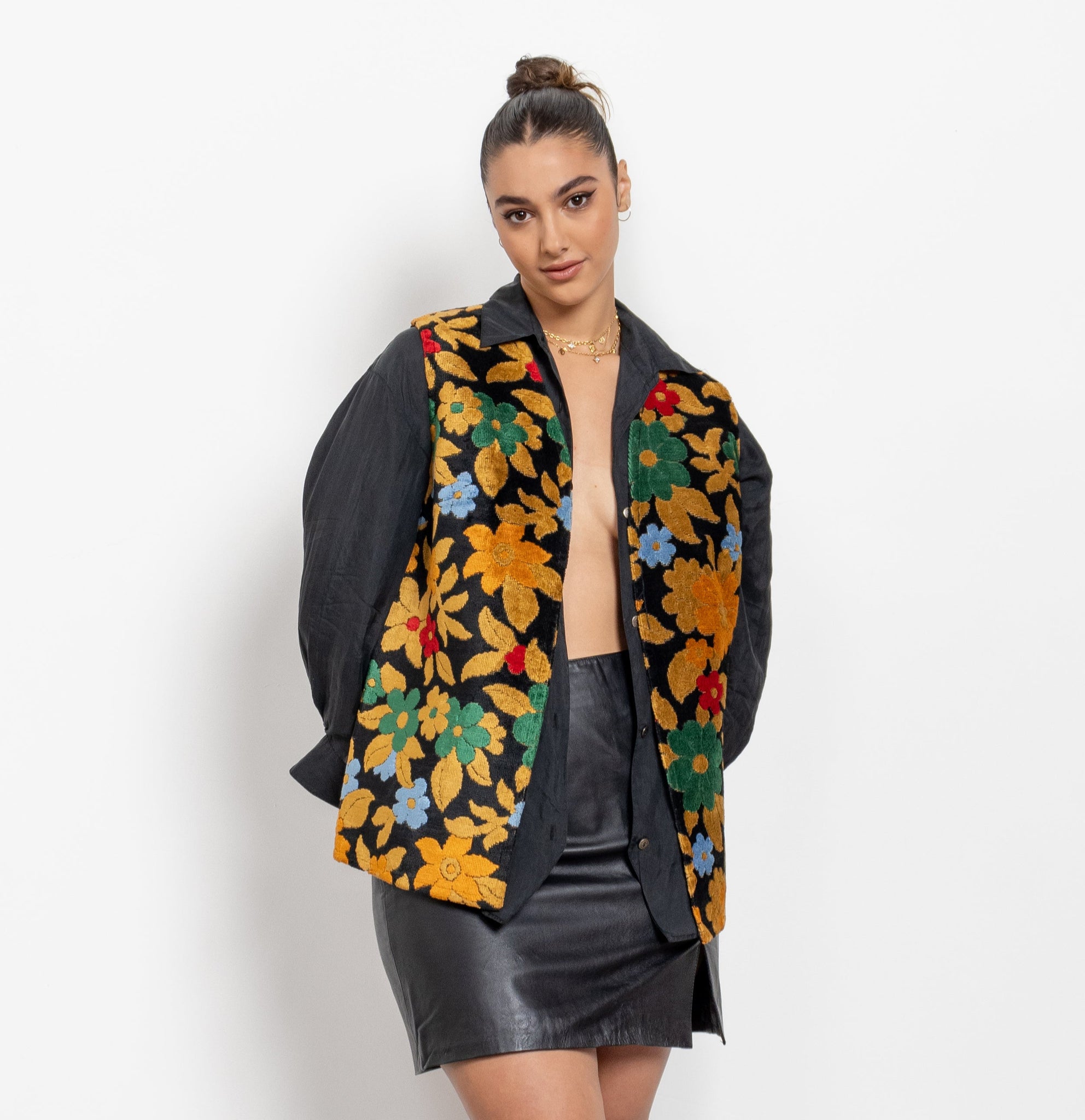 Person wearing a floral embroidered jacket with a plain background