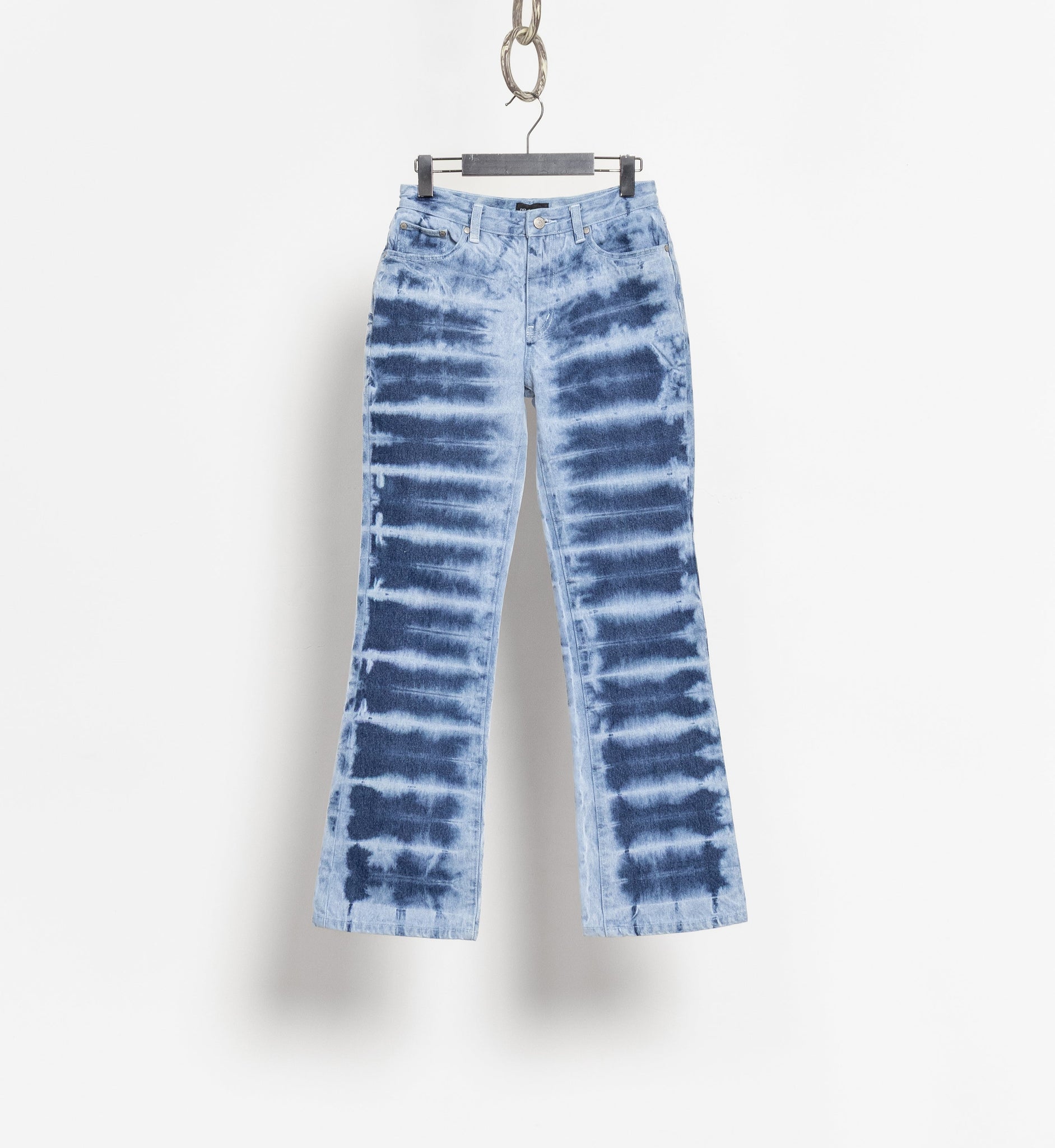 Tie-dye jeans on a hanger against a white background