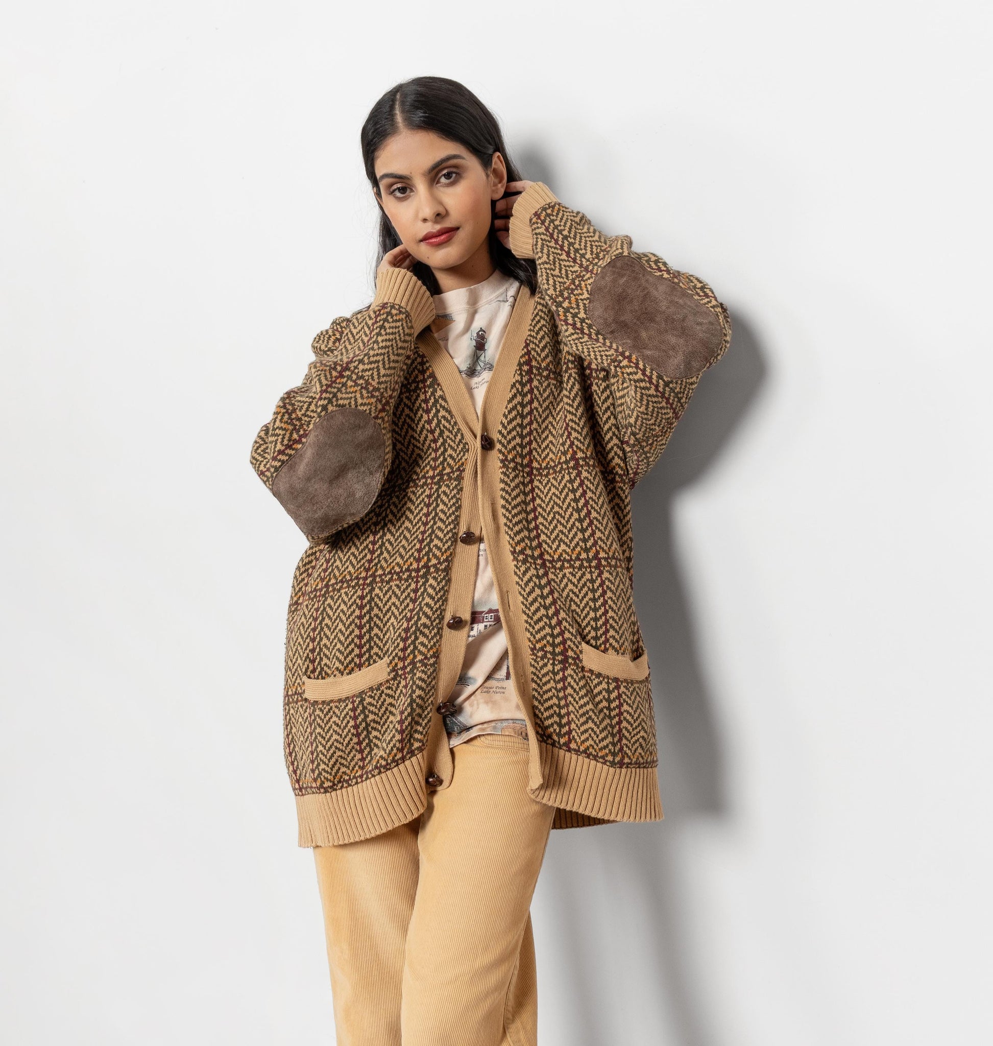 Woman wearing a brown patterned cardigan on a white background