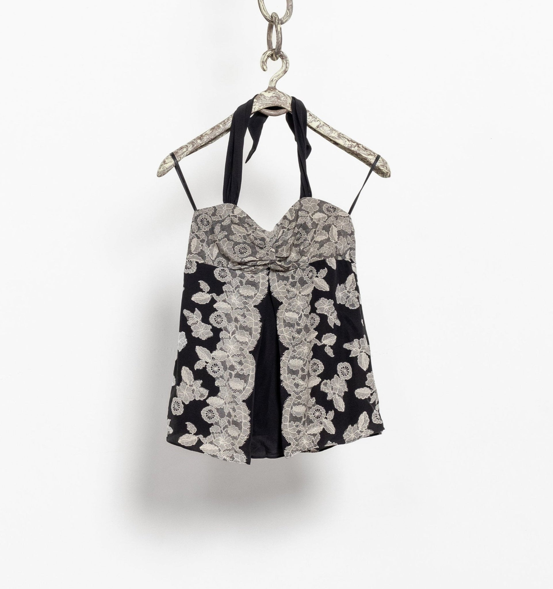 Black and white floral dress on a hanger against a white background