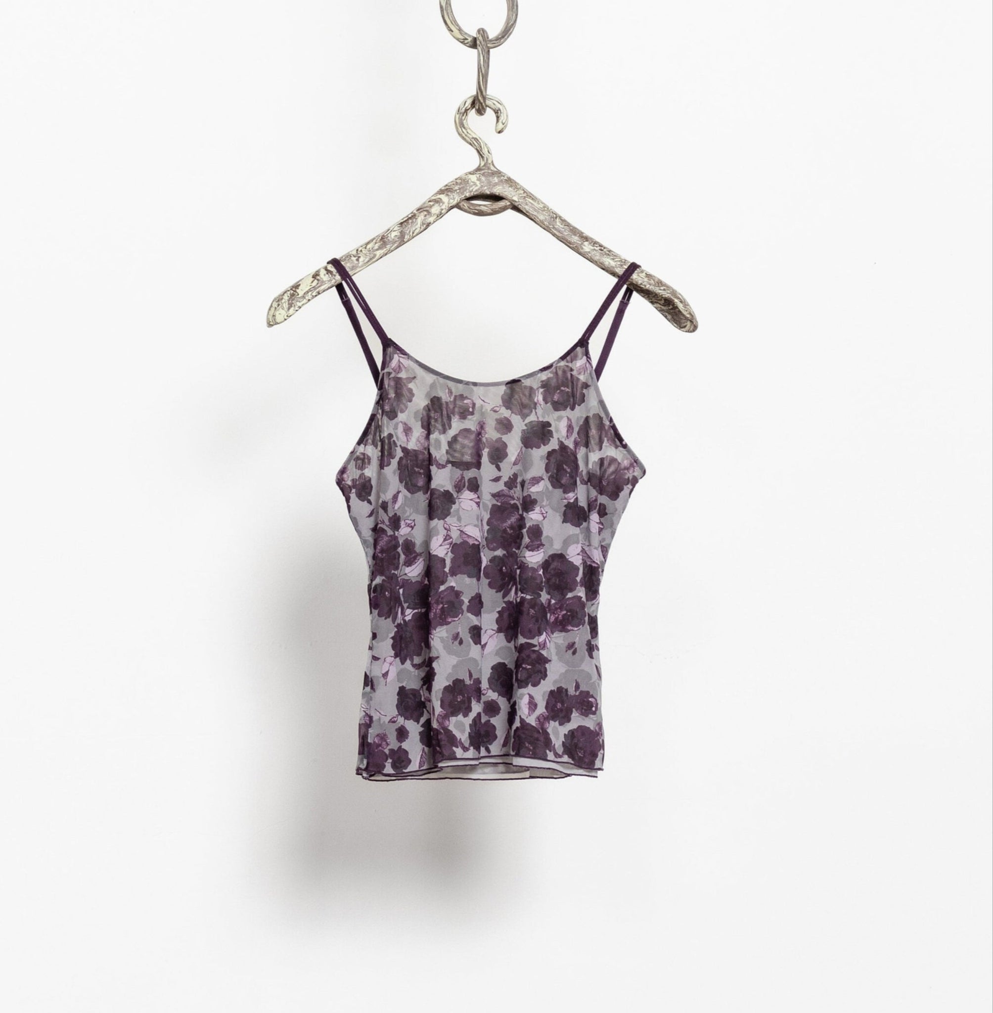 Floral-patterned tank top on a hanger against a white background