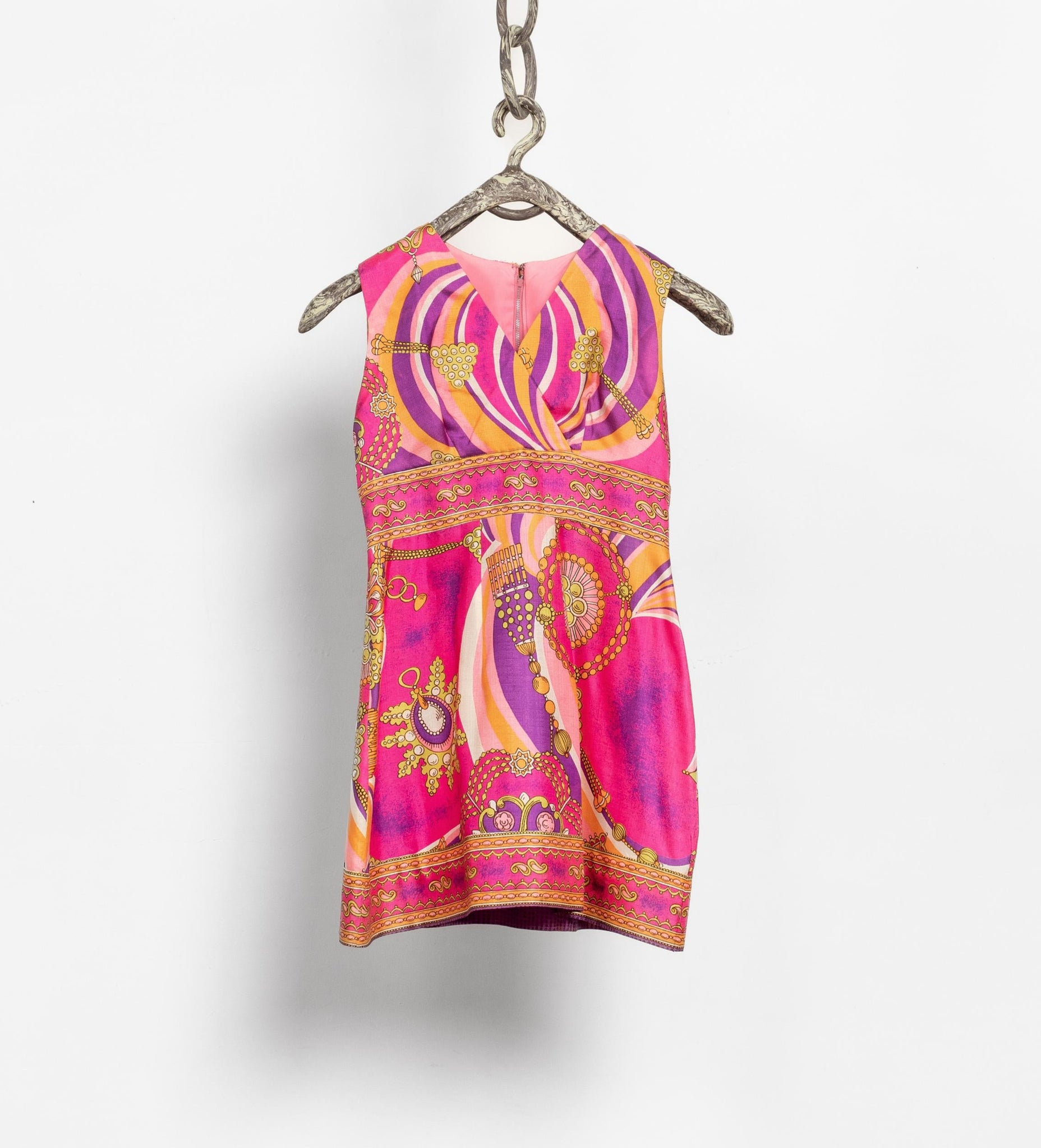 Colorful patterned dress hanging on a white background