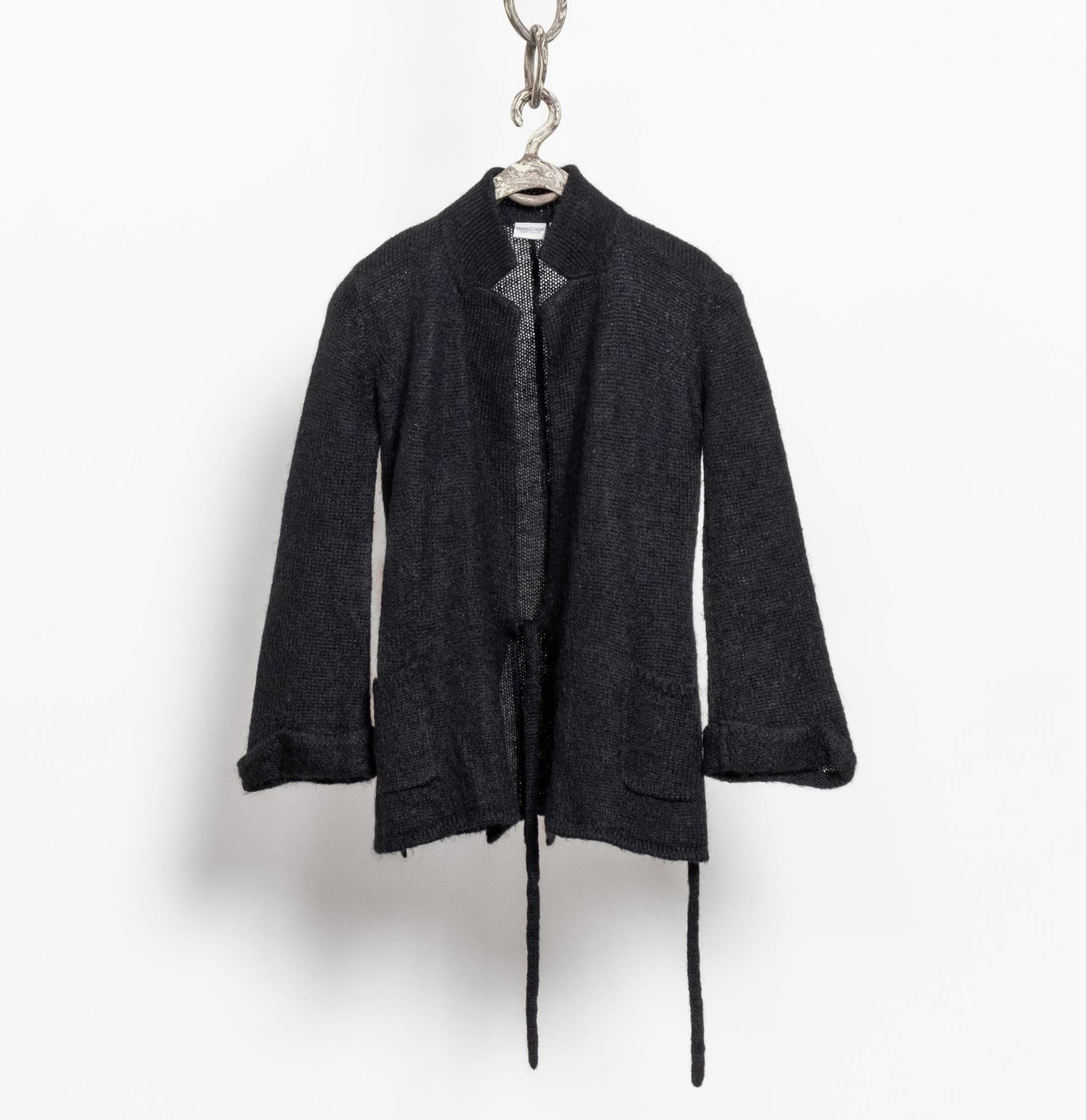 Black cardigan hanging on a white background
