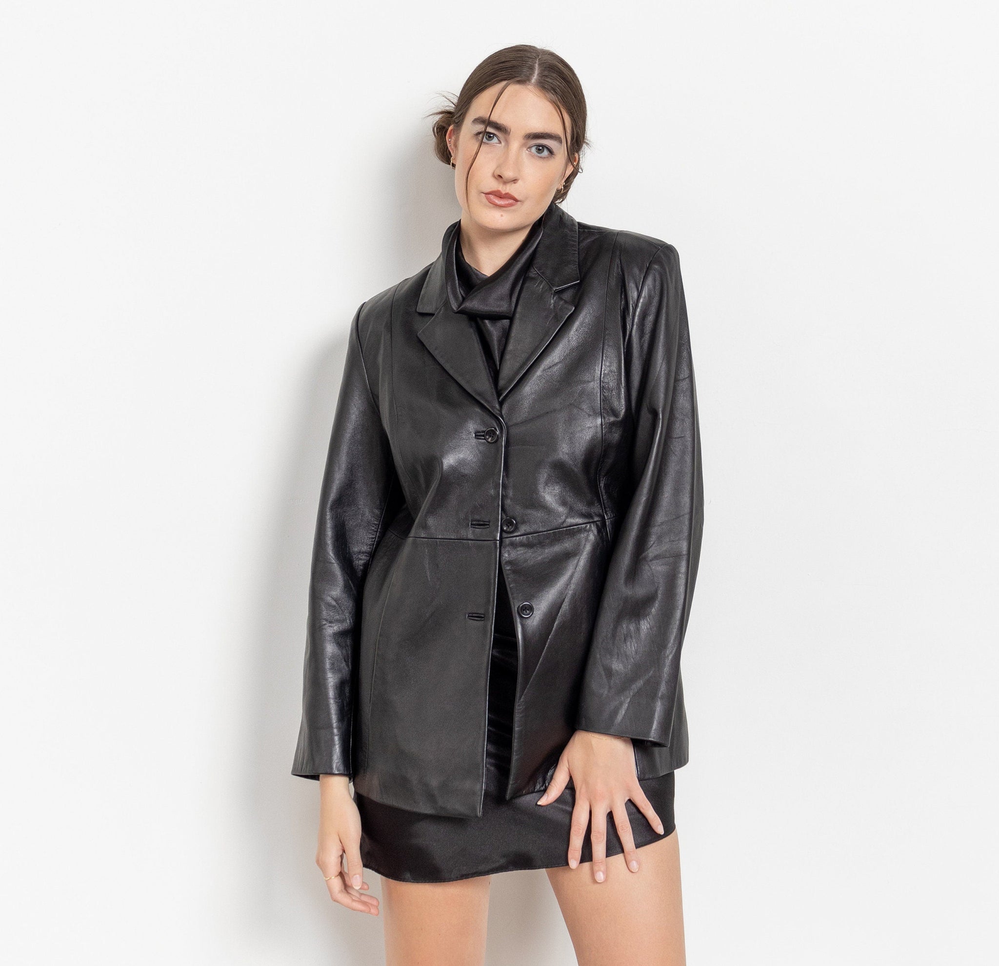 Person wearing a black leather jacket and skirt on a white background