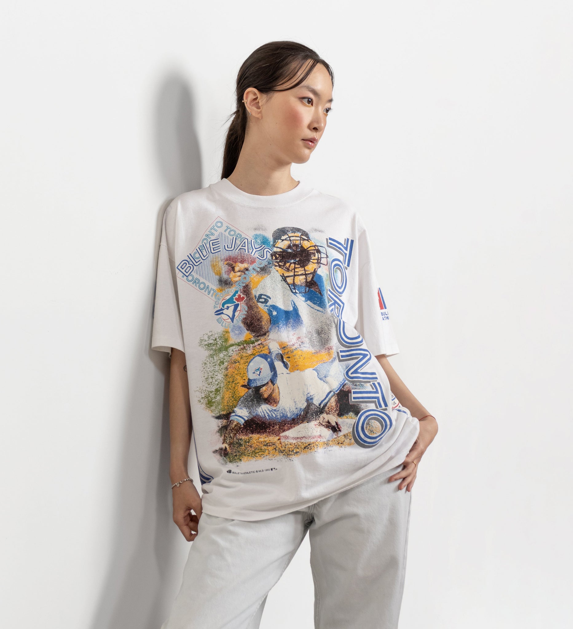 Person wearing a graphic t-shirt with a colorful design on a plain background