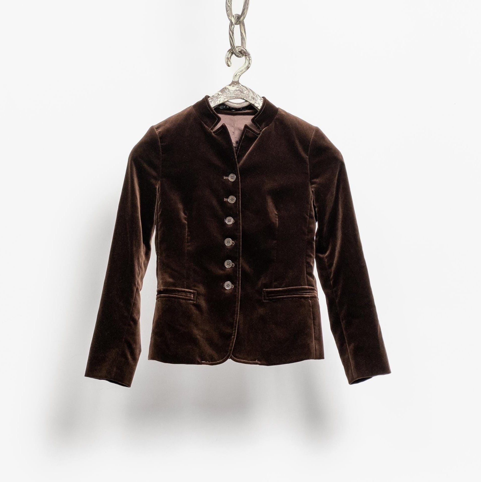Brown velvet jacket on a hanger against a white background