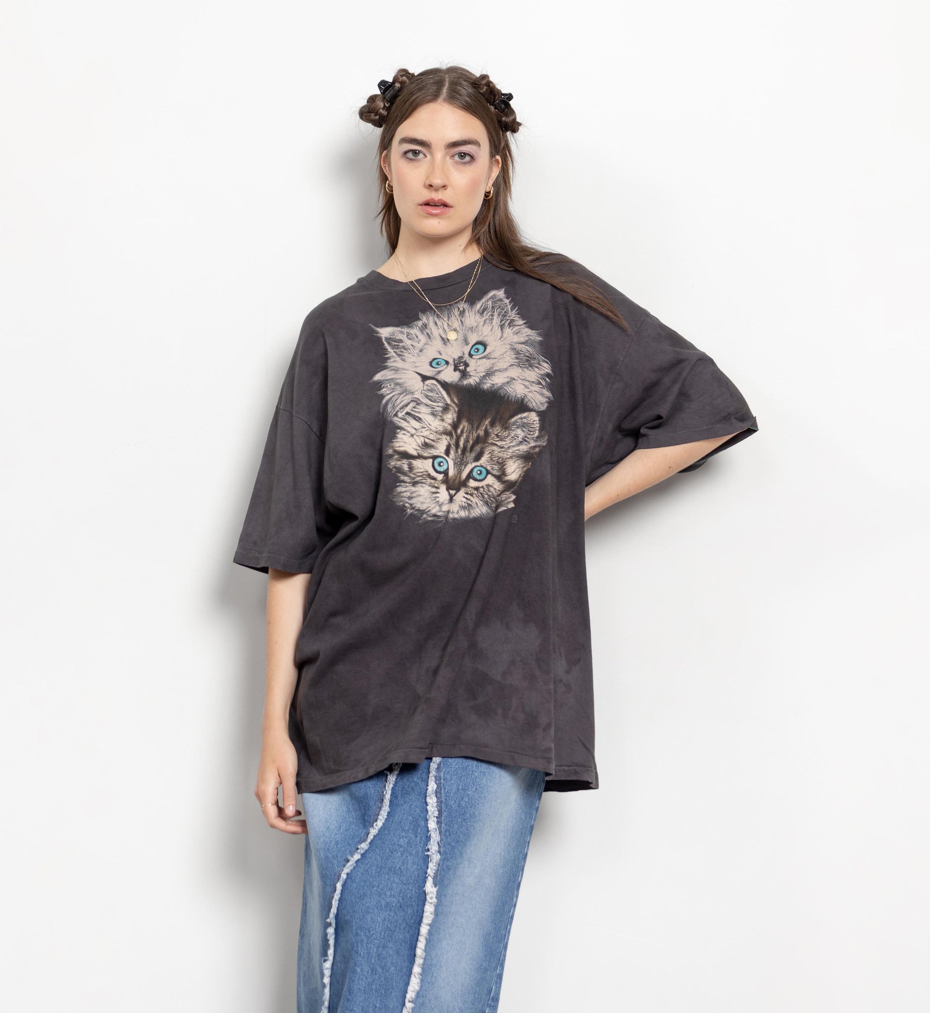 Person wearing a dark gray t-shirt with a cat graphic design on a white background