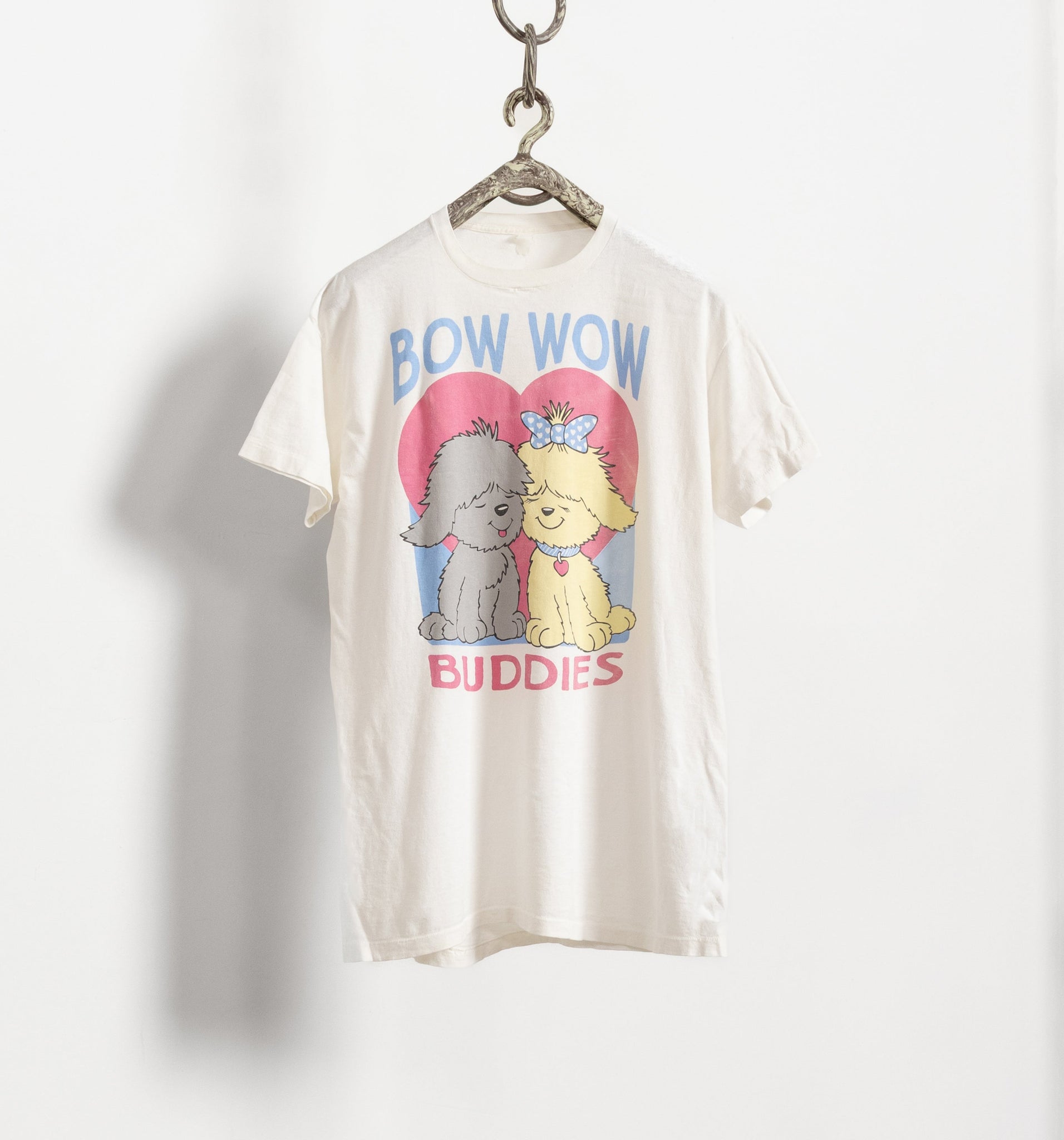 White t-shirt with cartoon dogs and 'Bow Wow Buddies' text on a white background
