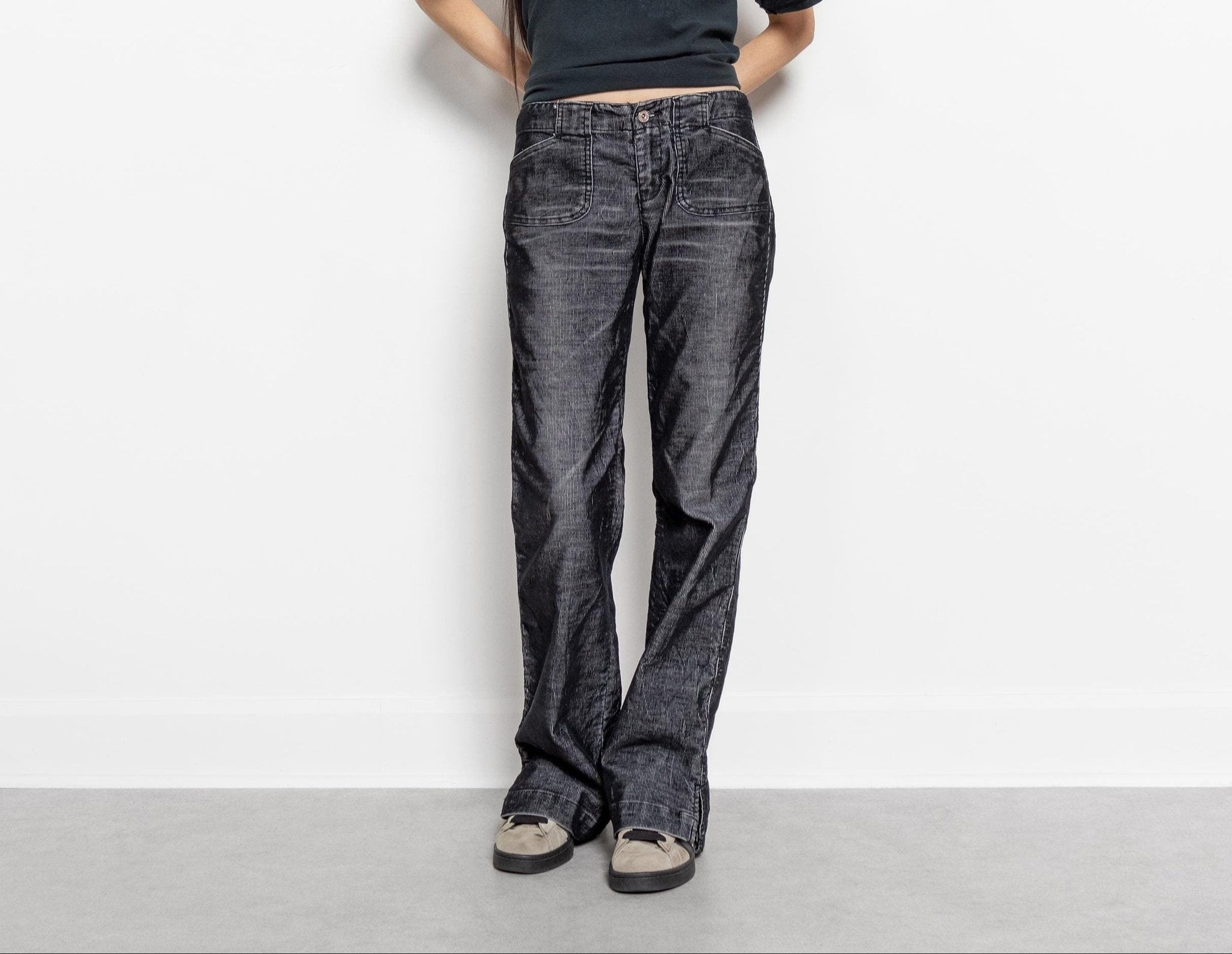 Person wearing dark blue jeans against a plain white background