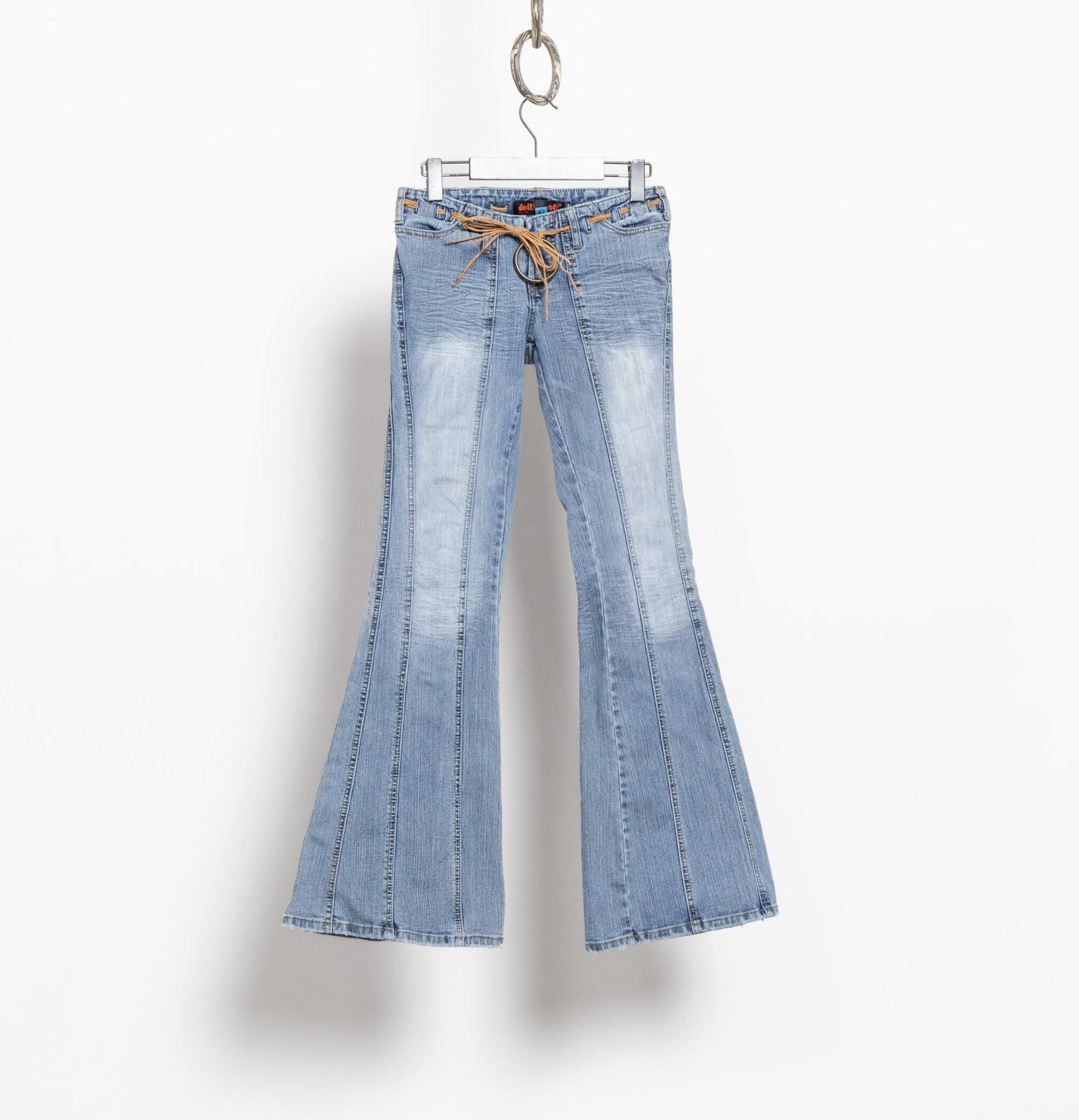 Light blue flared jeans on a hanger against a white background