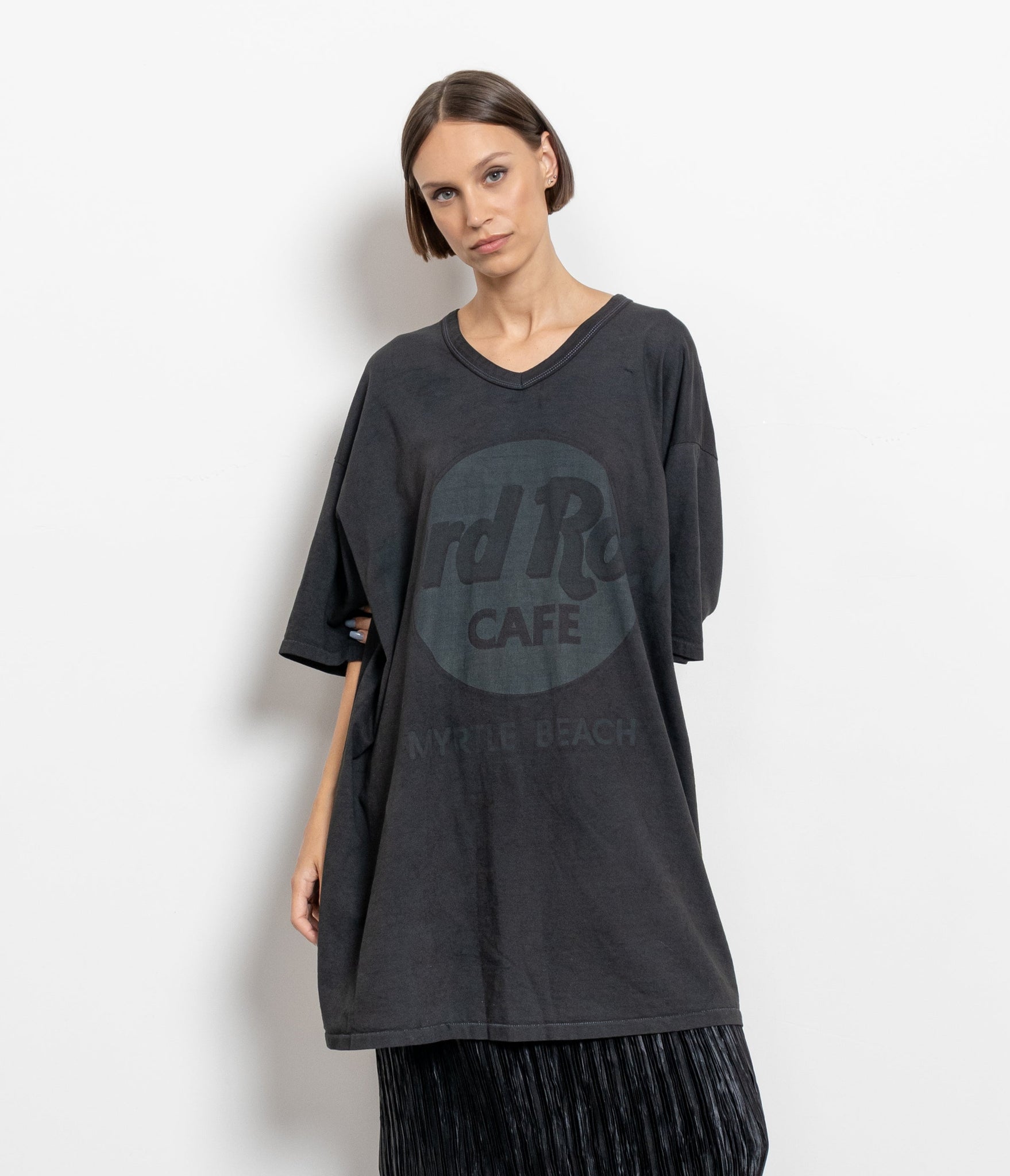 A woman modeling a vintage black longline tee with a larger oversize Hard Rock logo printed on the front.
