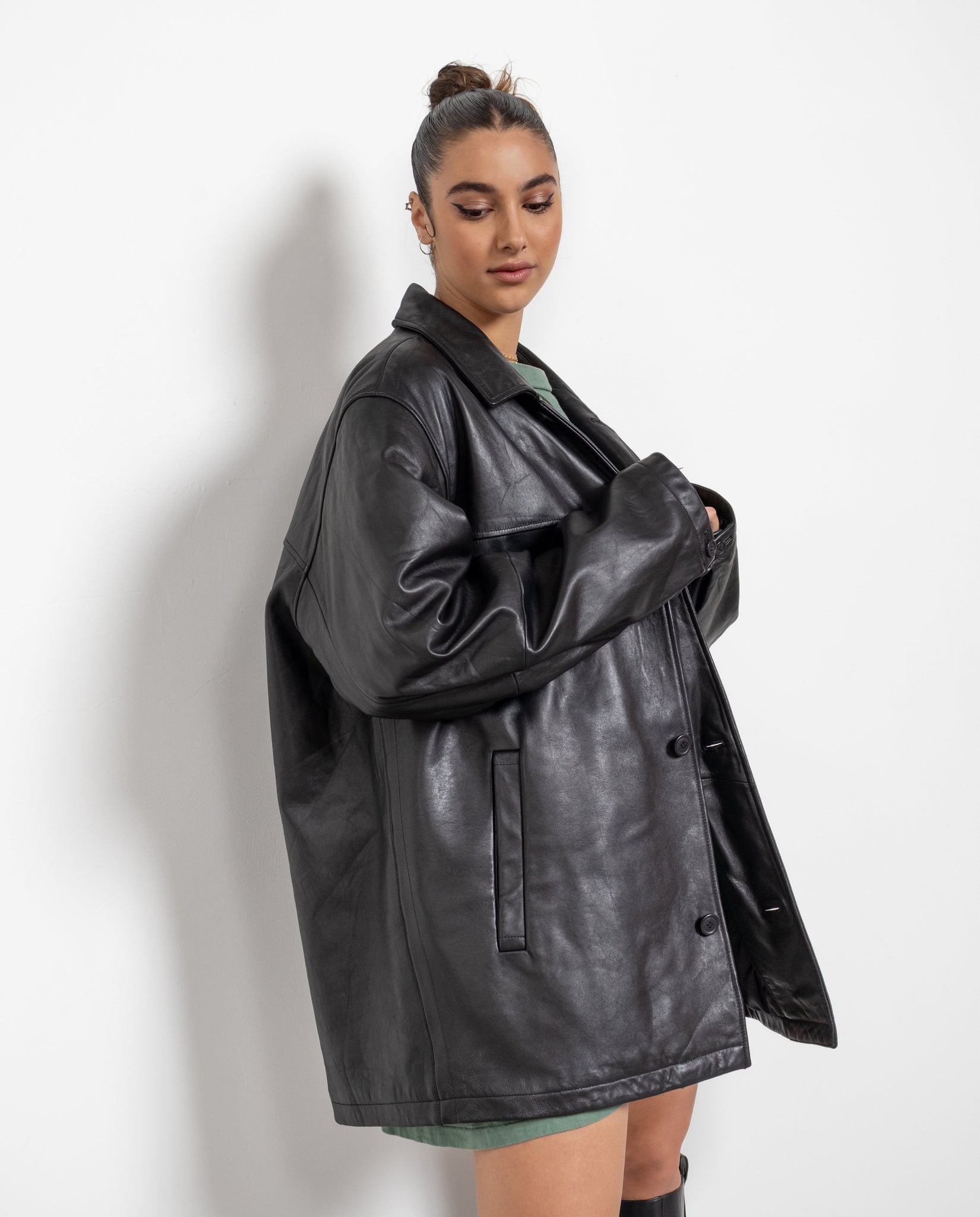 Woman wearing a black leather jacket against a white background