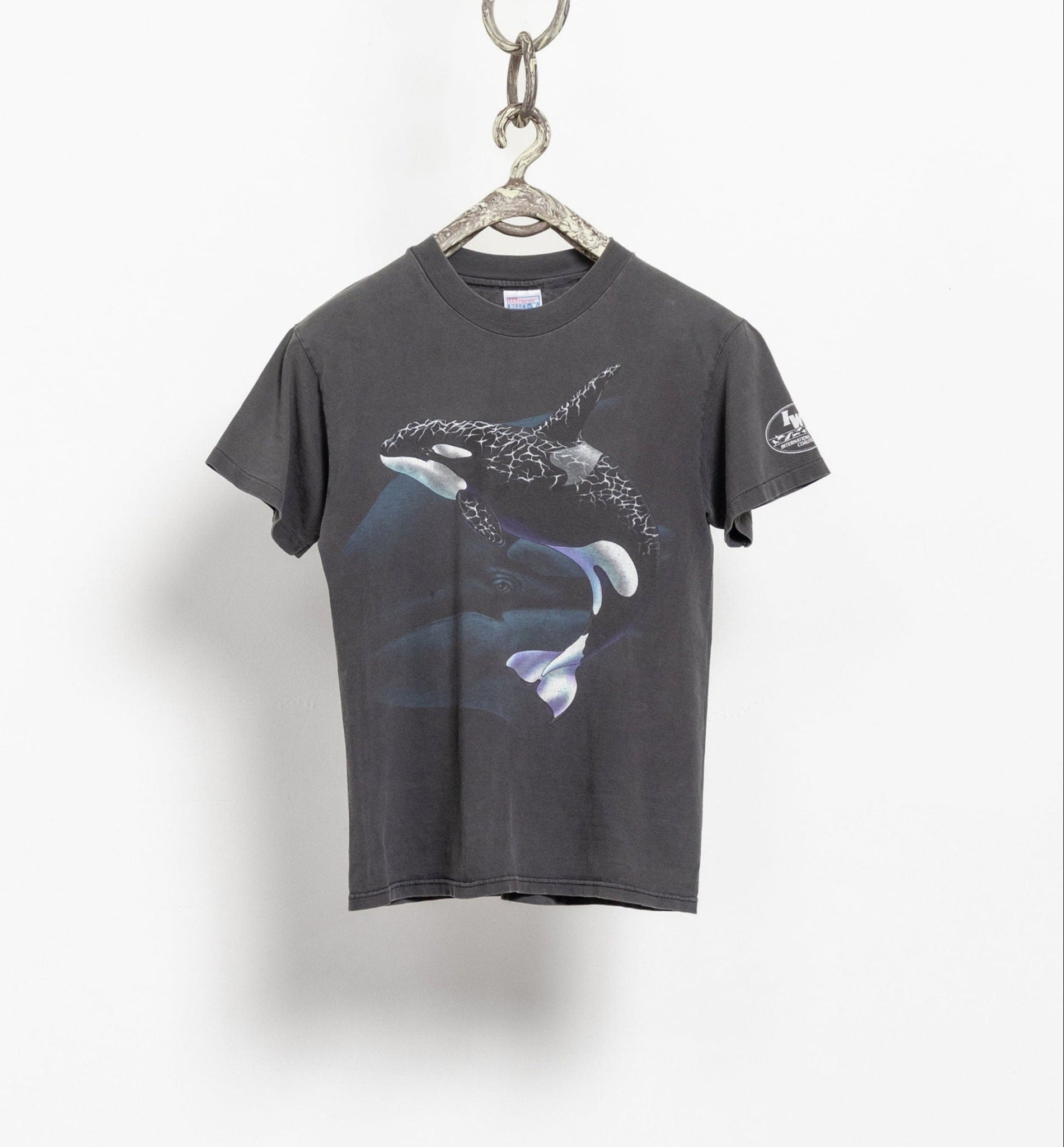 A gray t-shirt with a graphic print of a killer whale on the front, displayed on a hanger against a white background.