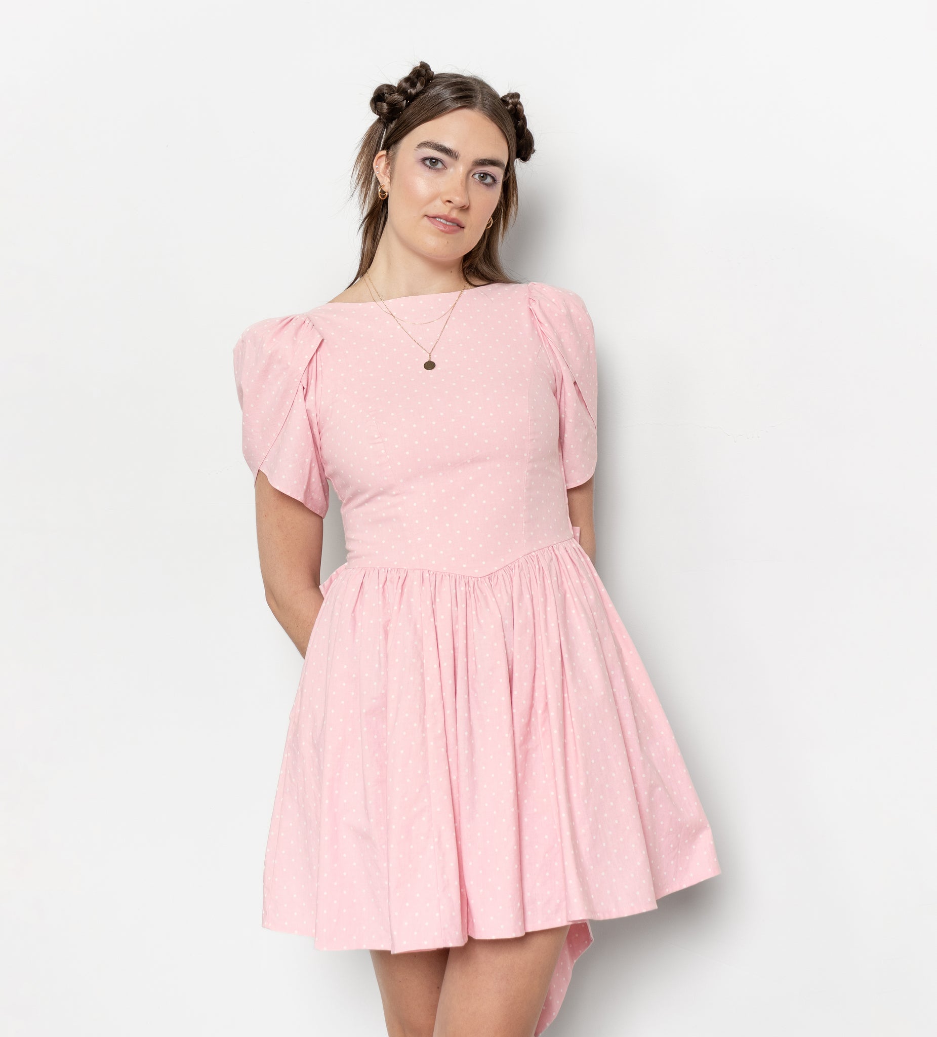 Woman wearing a pink dress against a white background