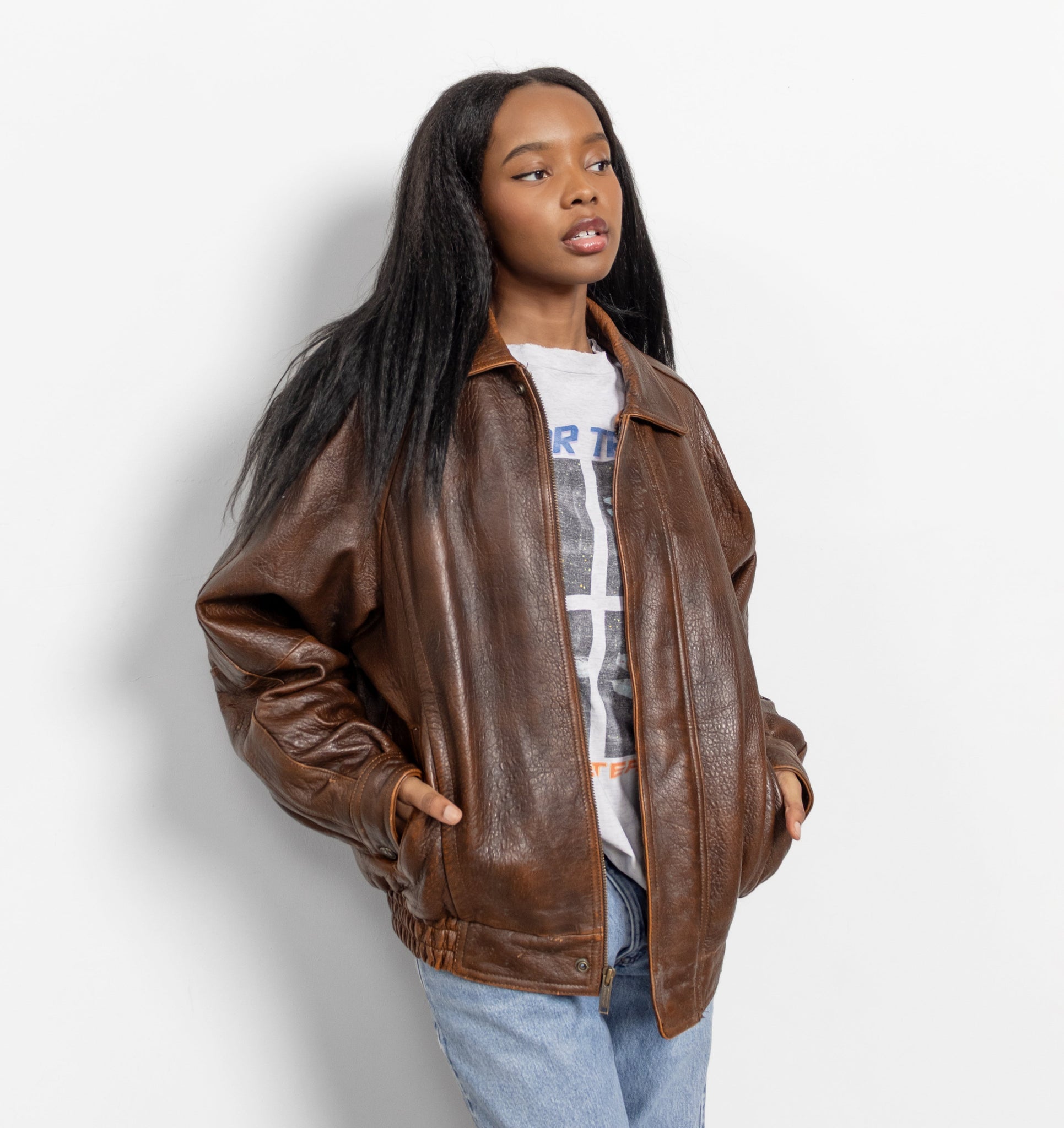 Person wearing a brown leather jacket on a white background