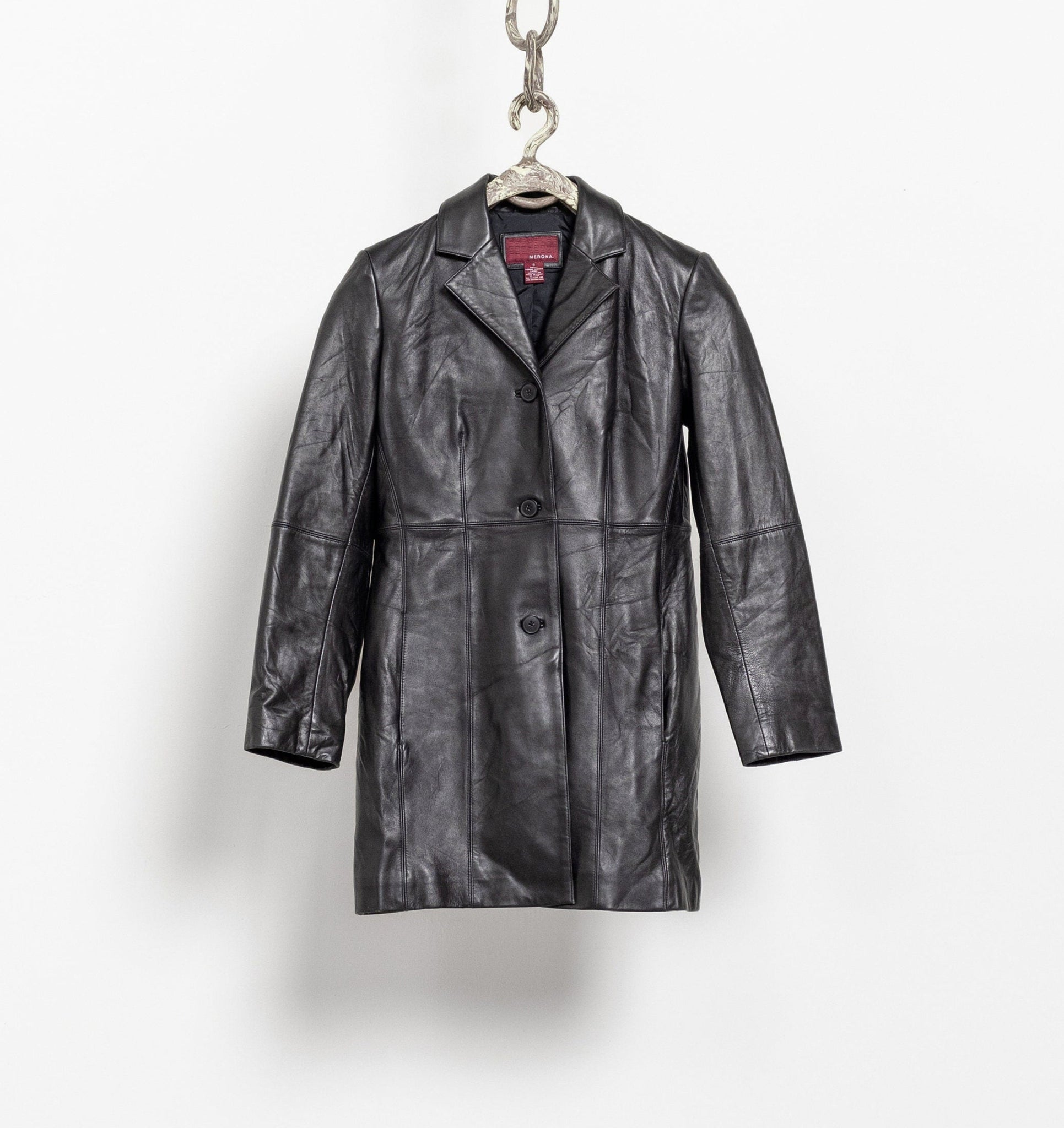 Black leather coat hanging on a white background