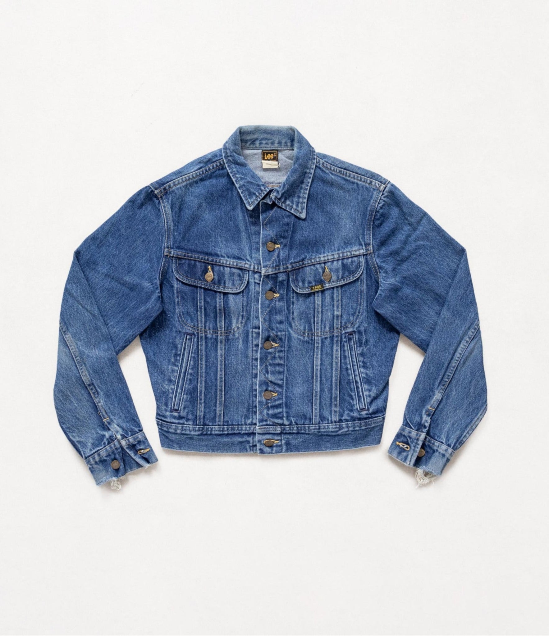Vintage Lee dark wash blue denim jacket laid flat on a white background