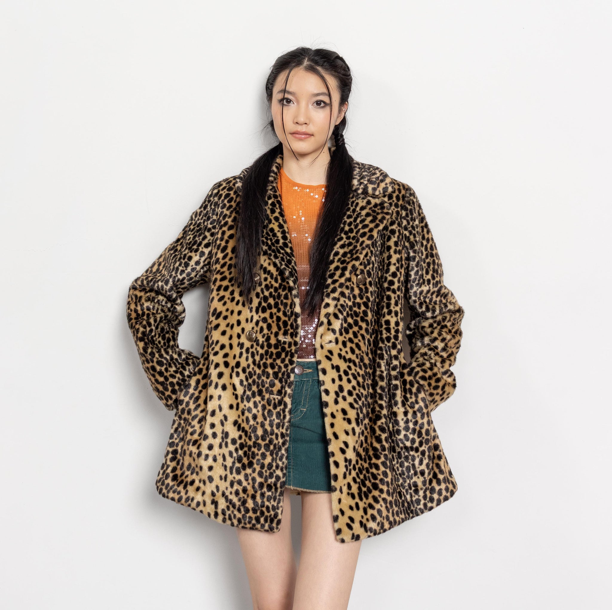 Person wearing a leopard print coat on a white background