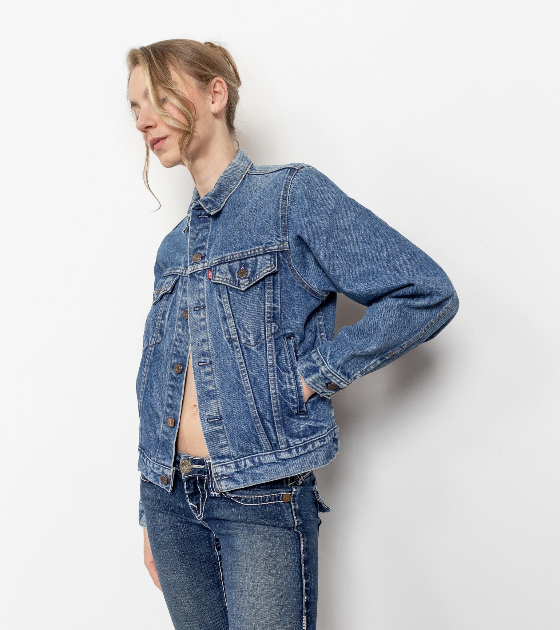 Person wearing a blue denim jacket against a white background