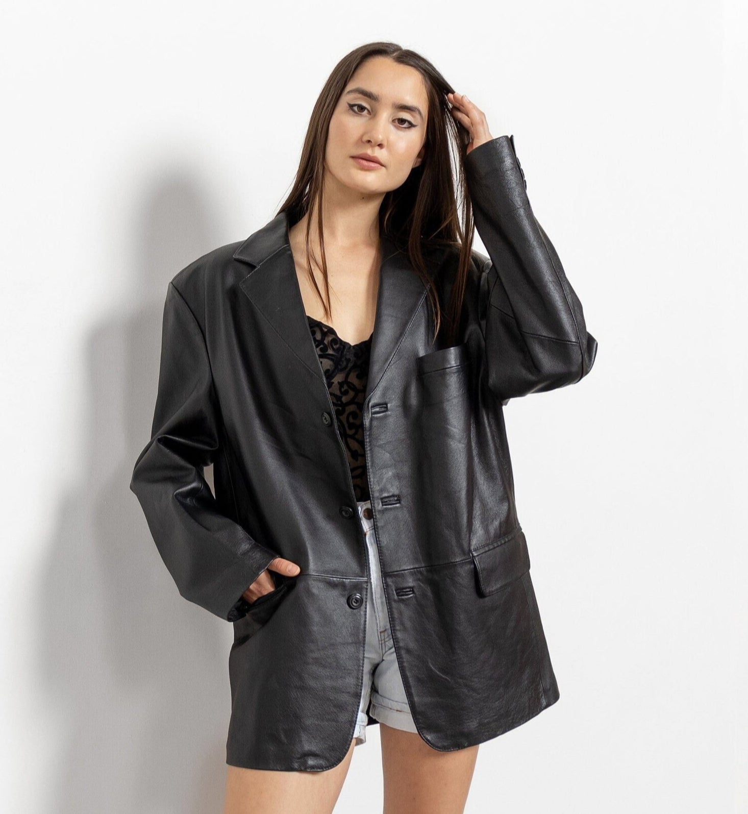 Person wearing a black leather jacket and boots on a white background