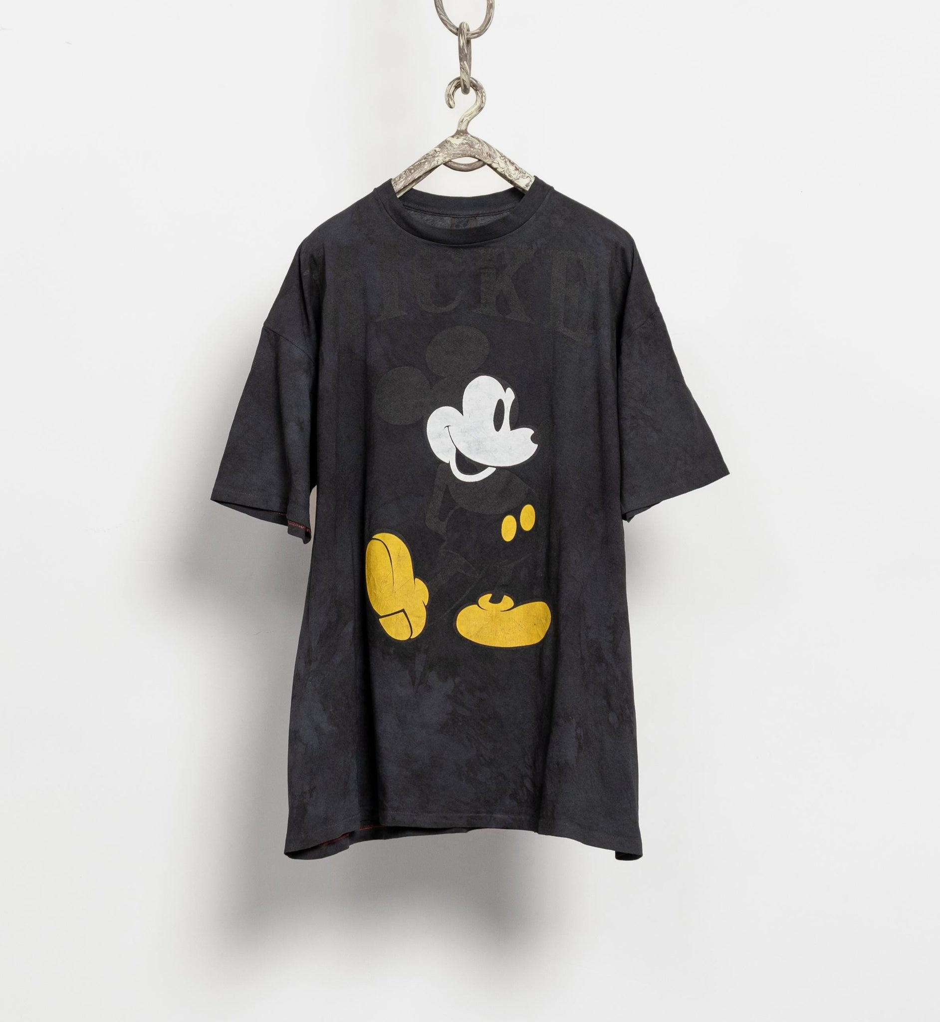 Black t-shirt with a cartoon character on a hanger against a white background