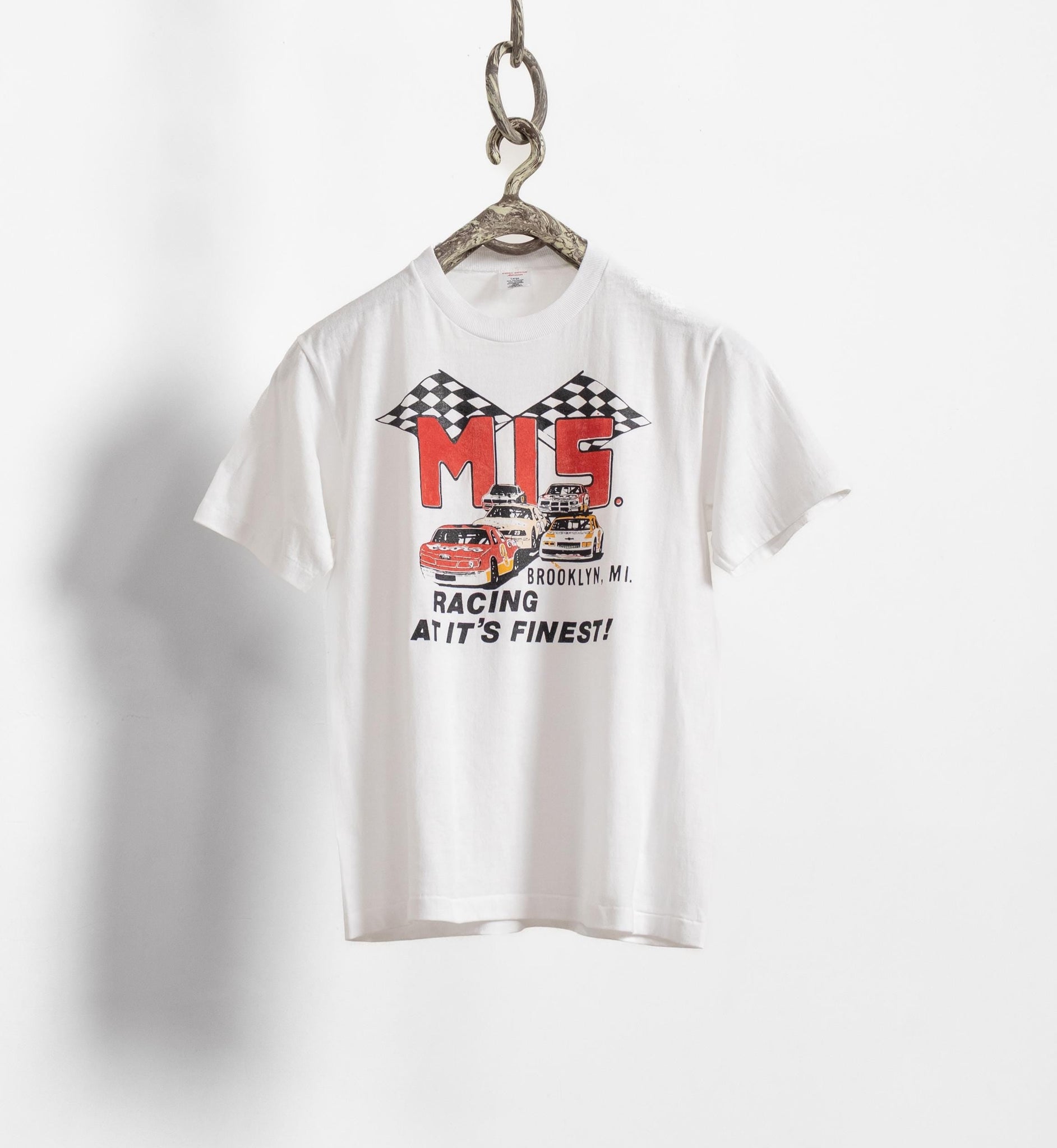 White t-shirt with racing graphic and text on a white background