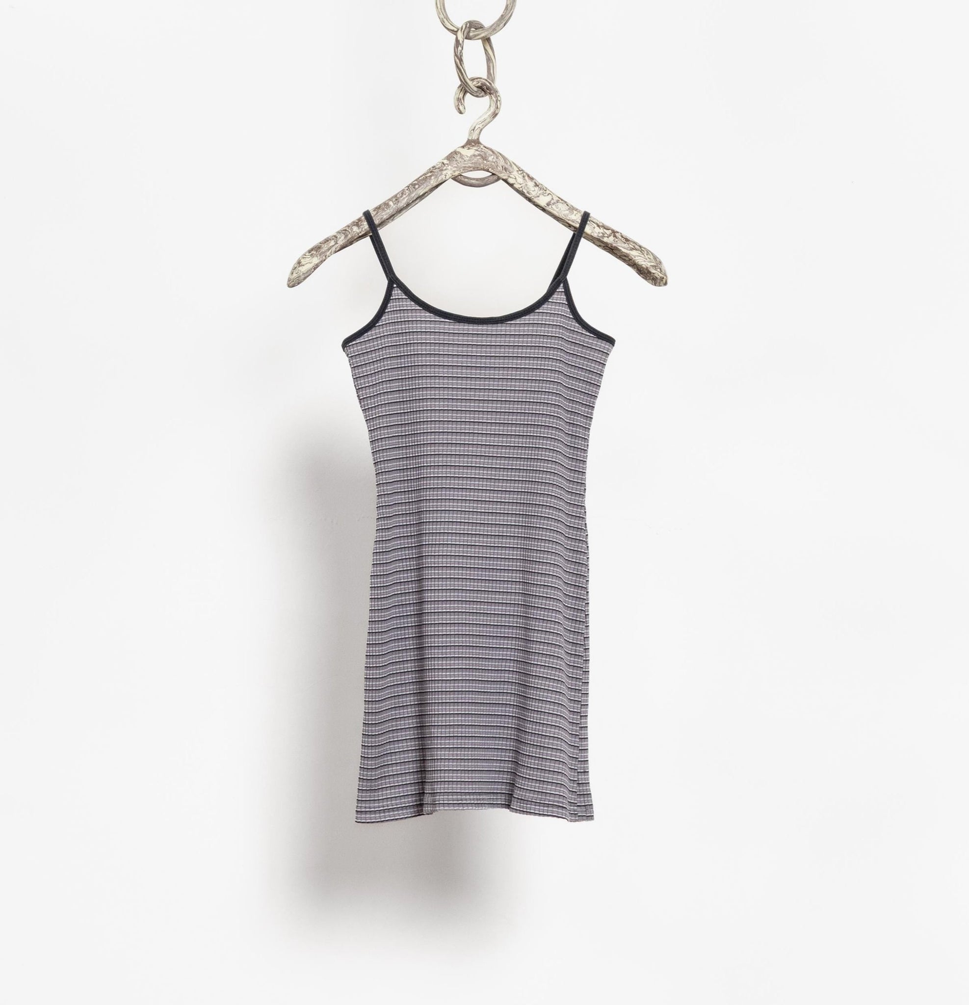 Striped tank top hanging on a hanger against a white background