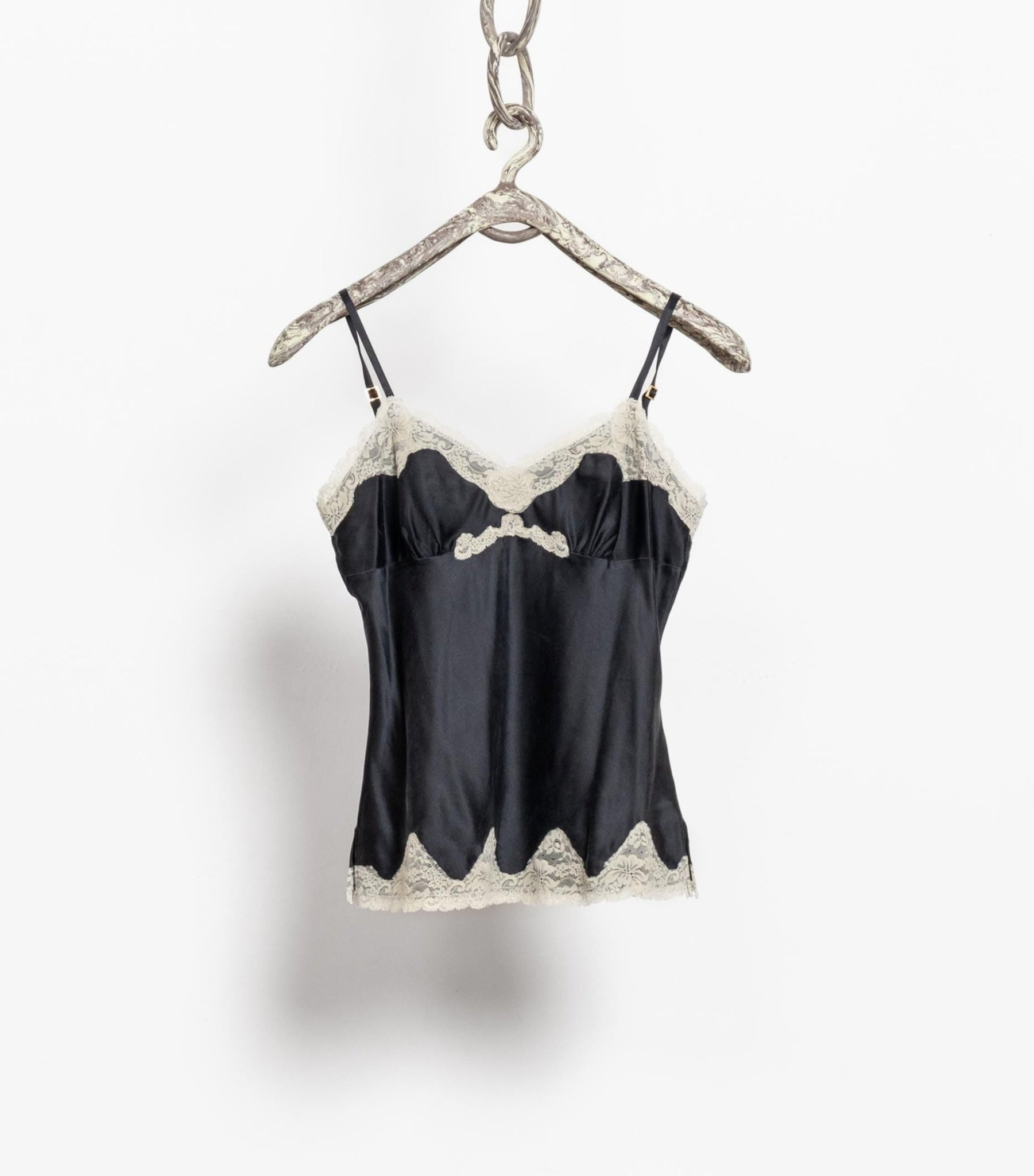 Black lace top on a hanger against a white background