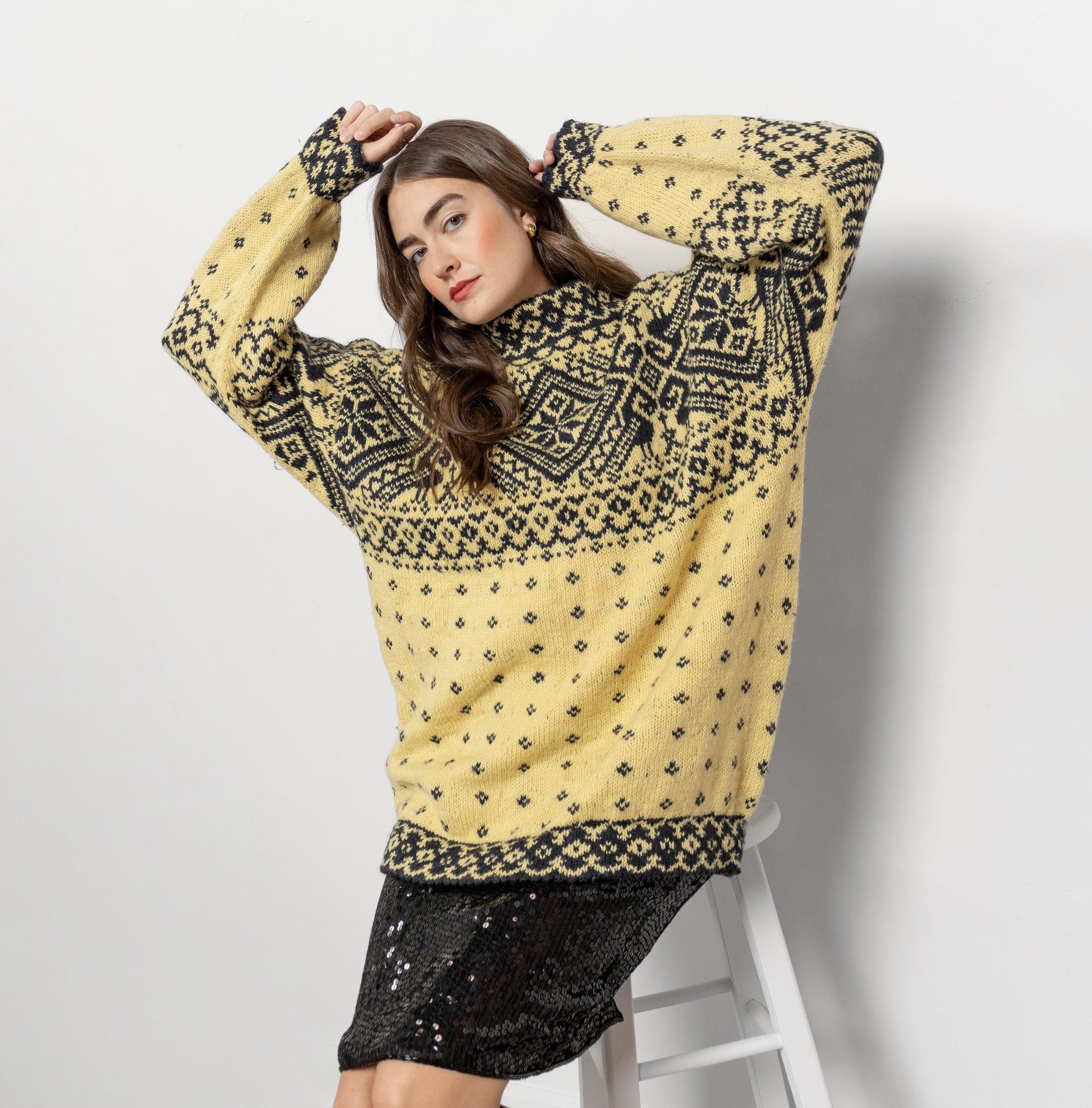 Woman wearing a yellow patterned sweater on a white background