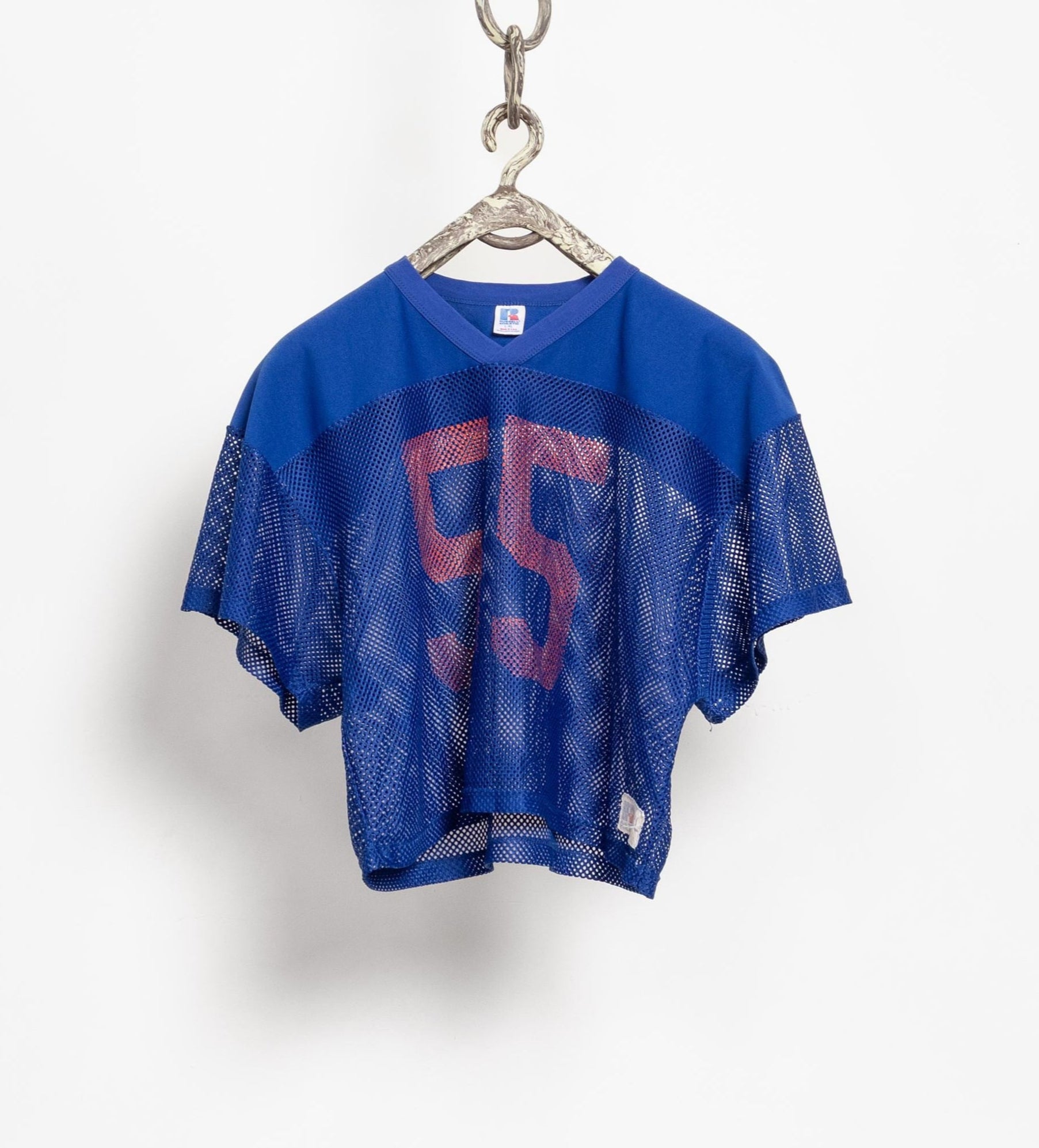 Blue mesh sports jersey with red number 5 on a hanger against a white background