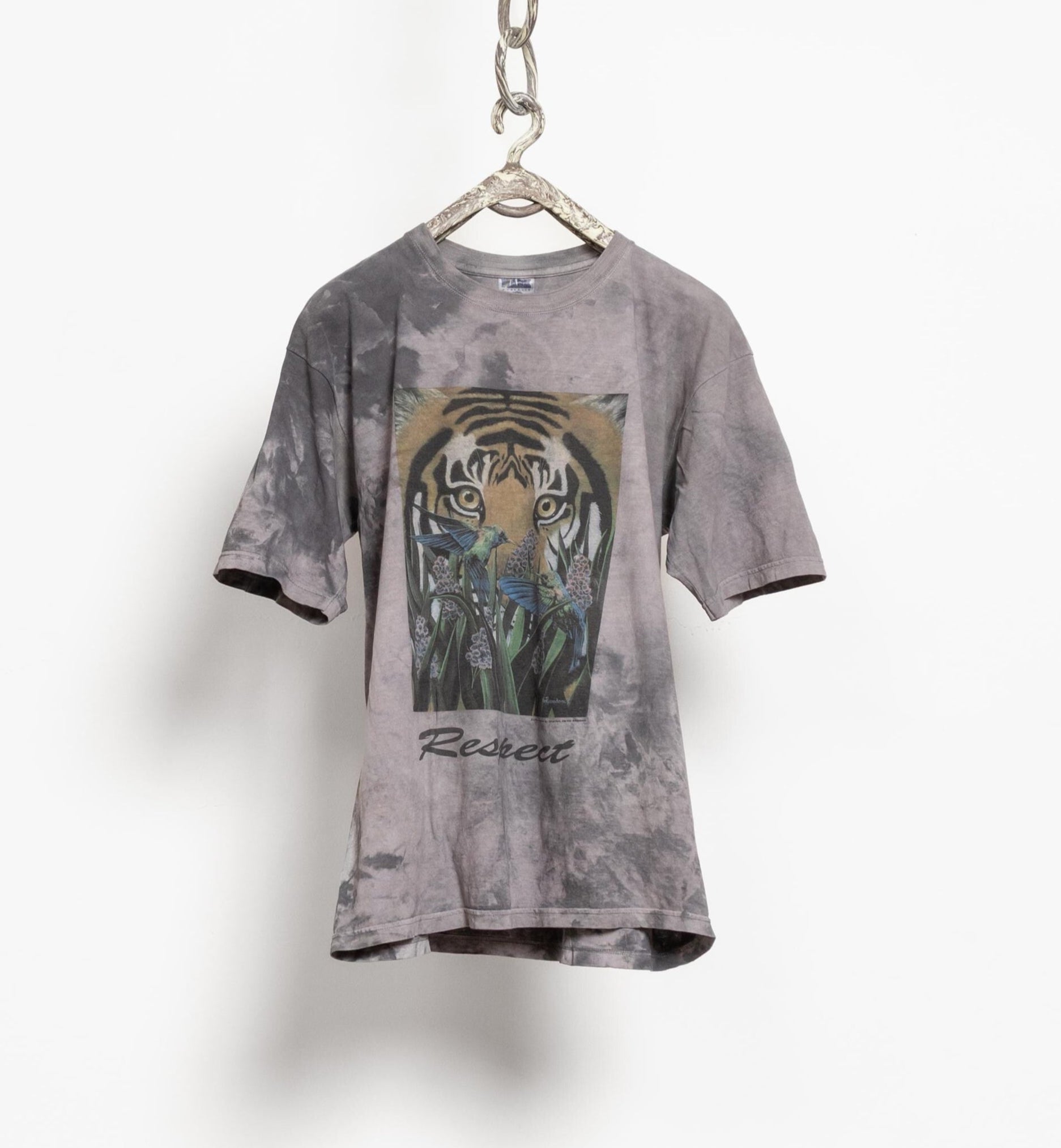 A vintage 90's gray tie dye t-shirt with a graphic of a tiger and butterflies, hanging on a hanger against a white background.