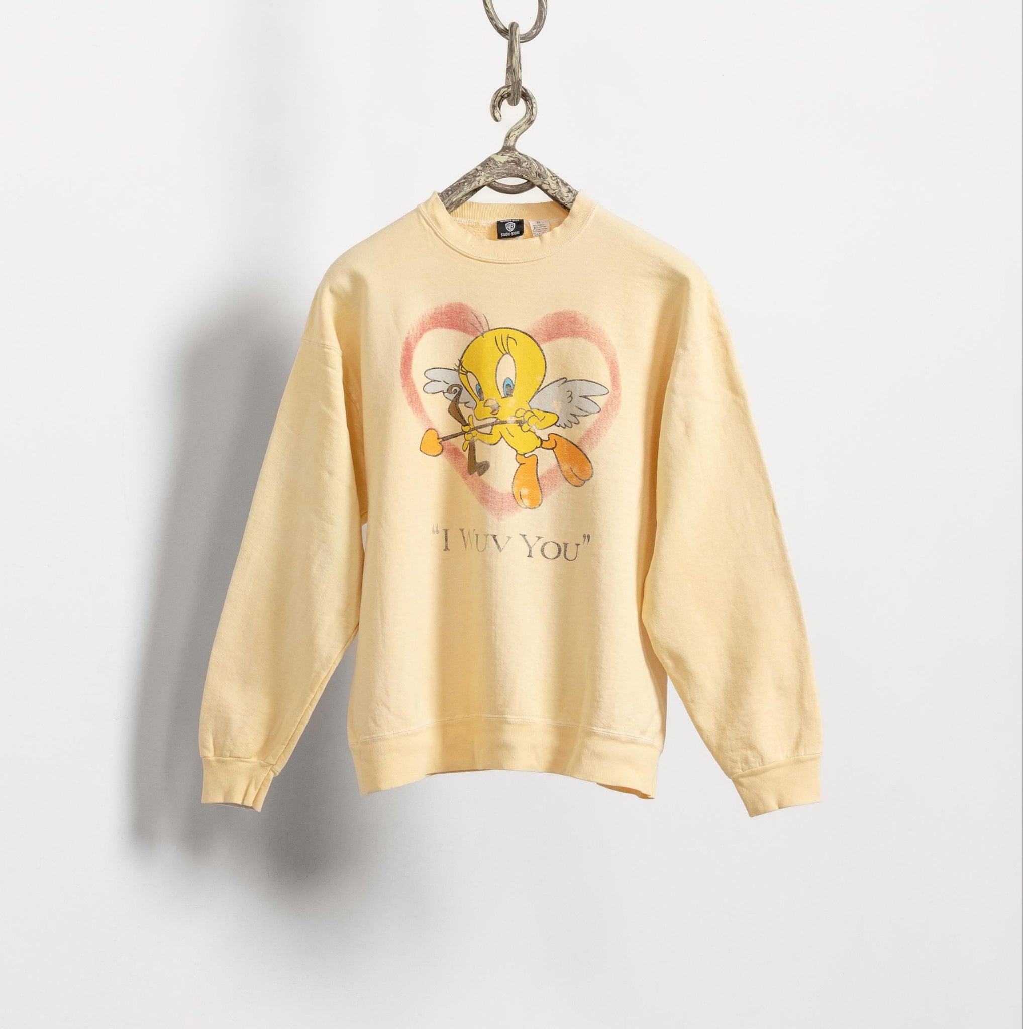 Yellow sweatshirt with cartoon character and text on a gray background