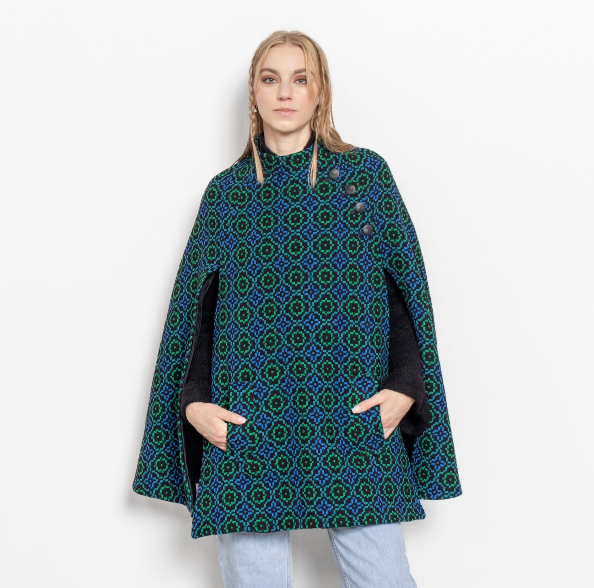 Person wearing a blue patterned cape on a white background