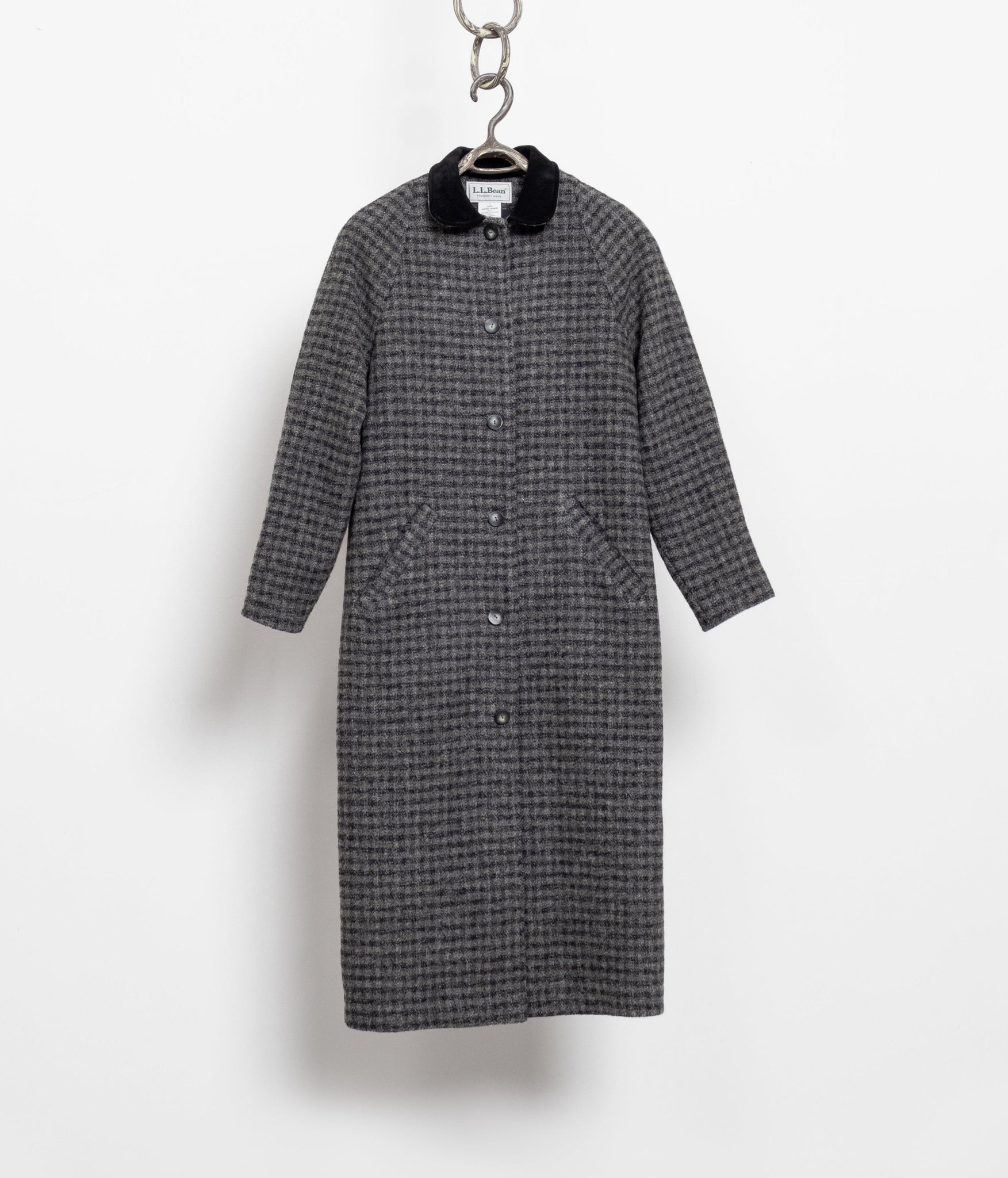 Gray checkered coat on a hanger against a white background