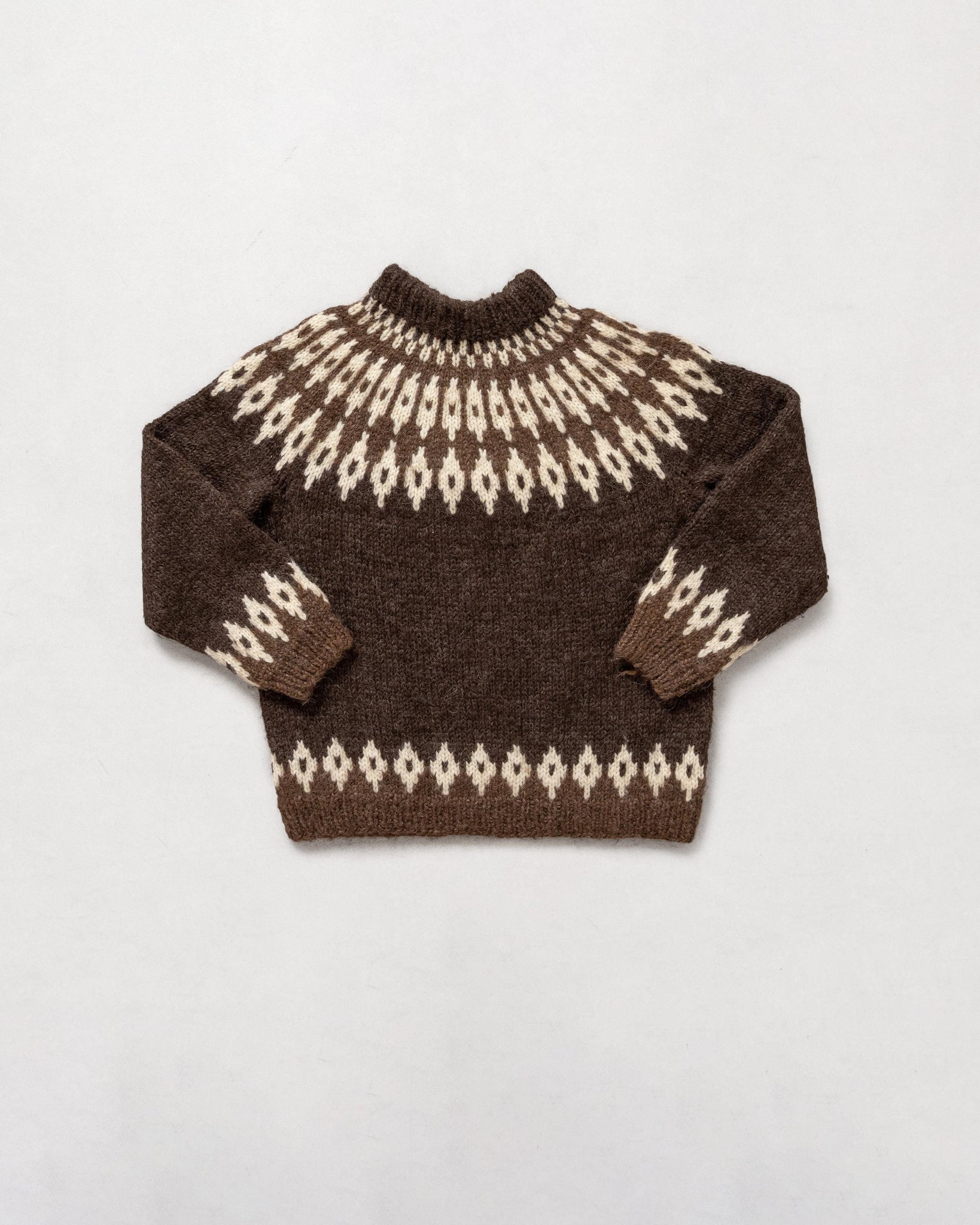 Brown sweater with a white pattern on a light gray background