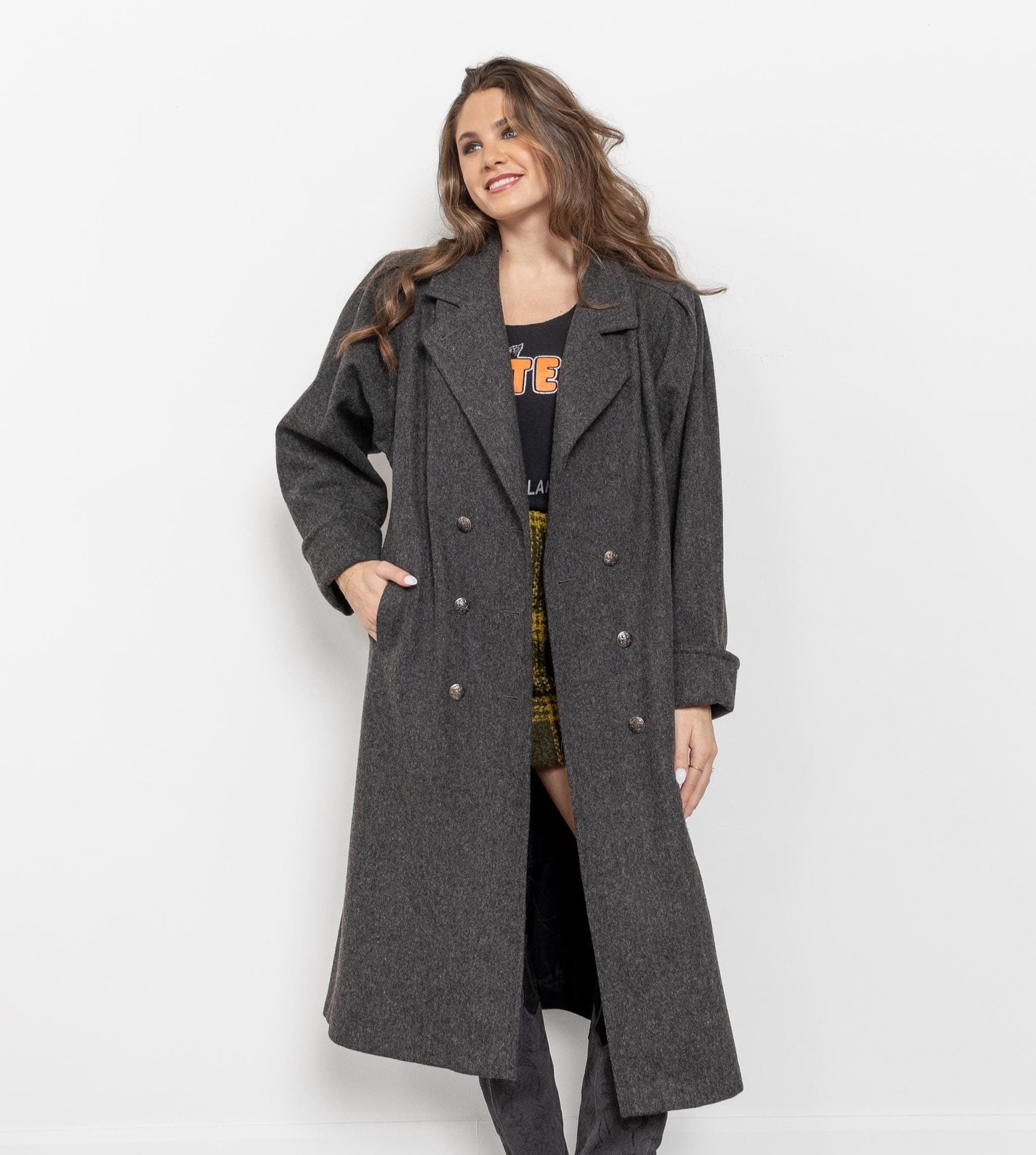 Woman wearing a long gray coat on a white background