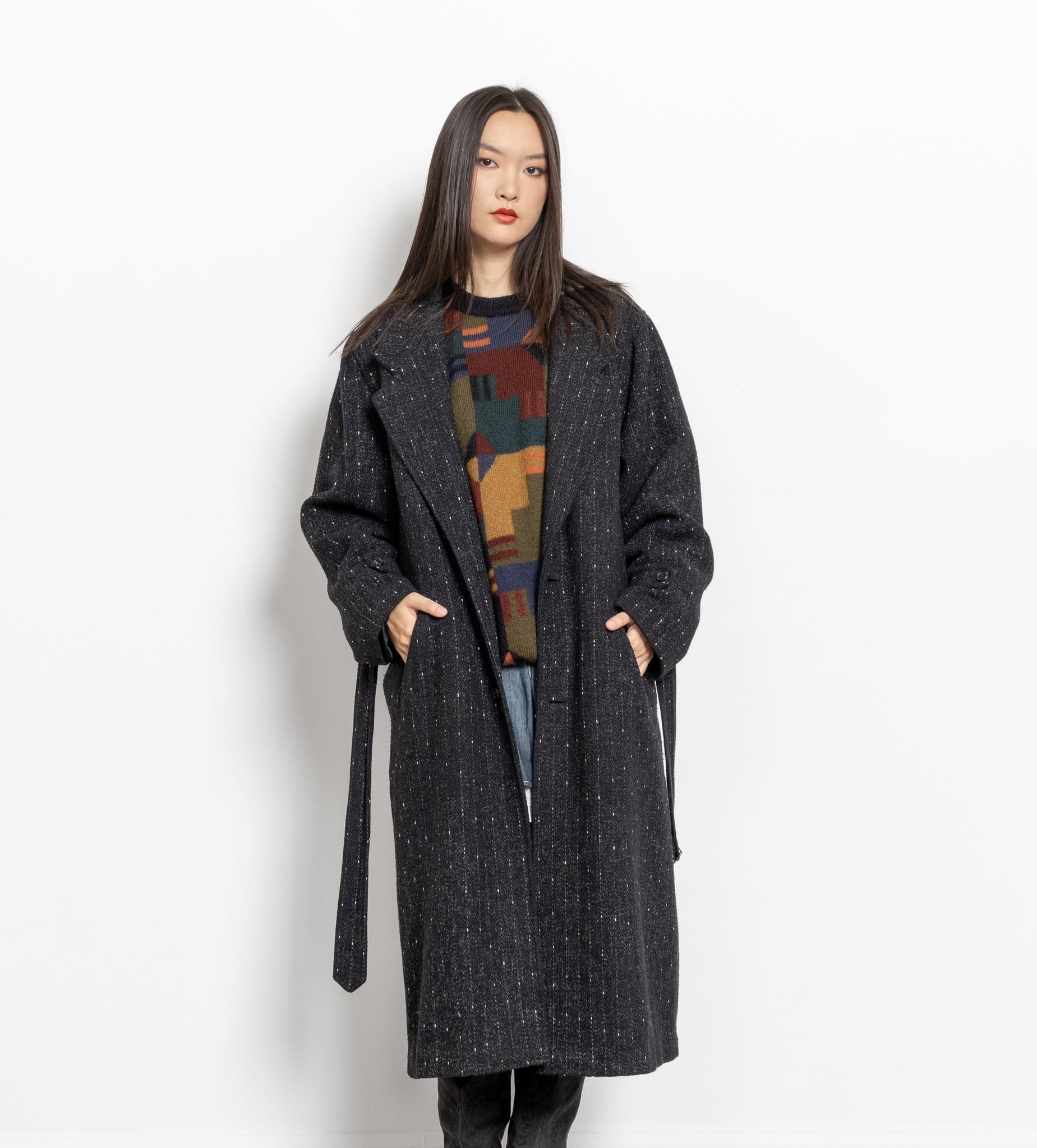 Woman wearing a long dark coat on a white background