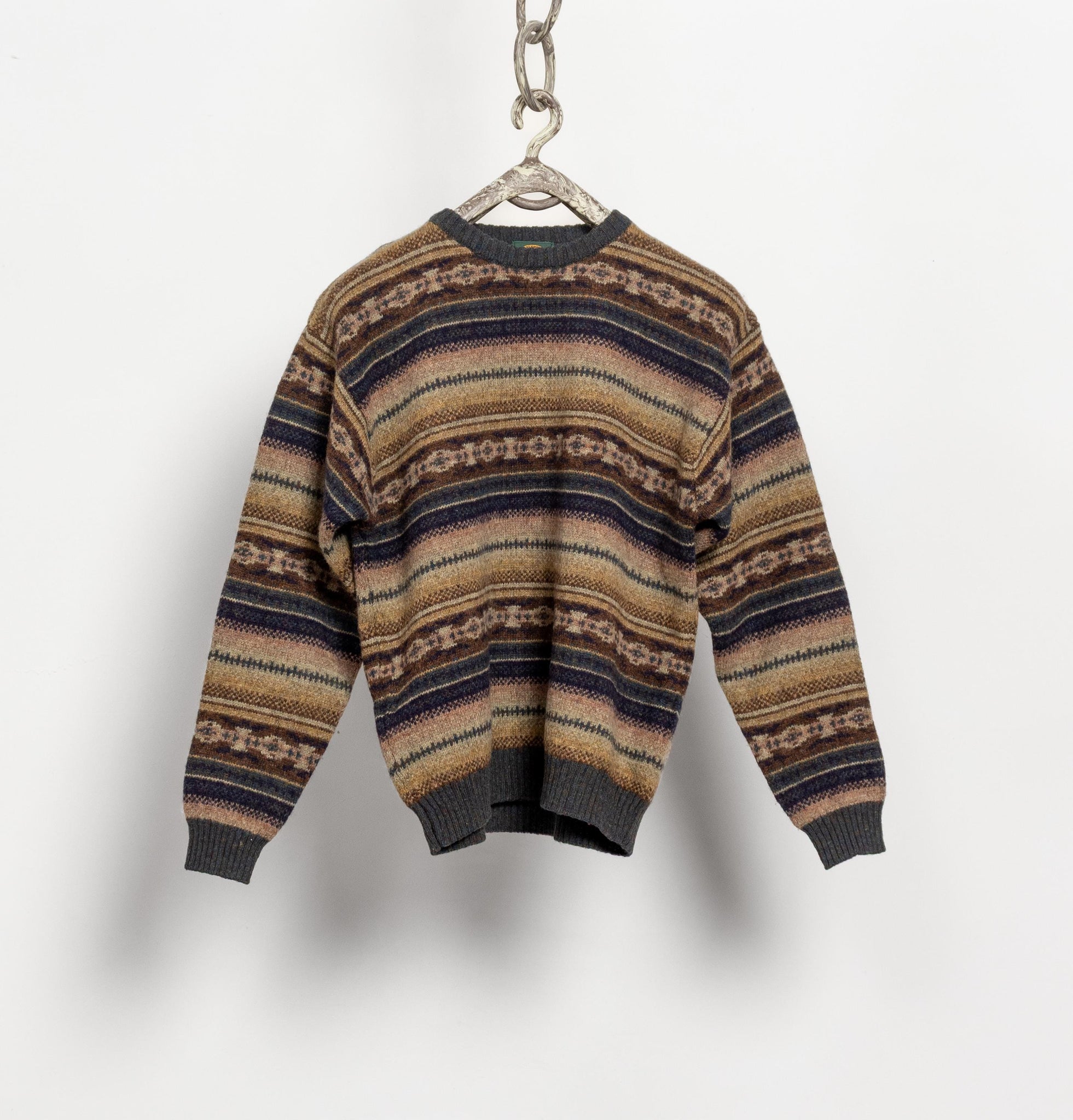 Striped sweater on a hanger against a plain background