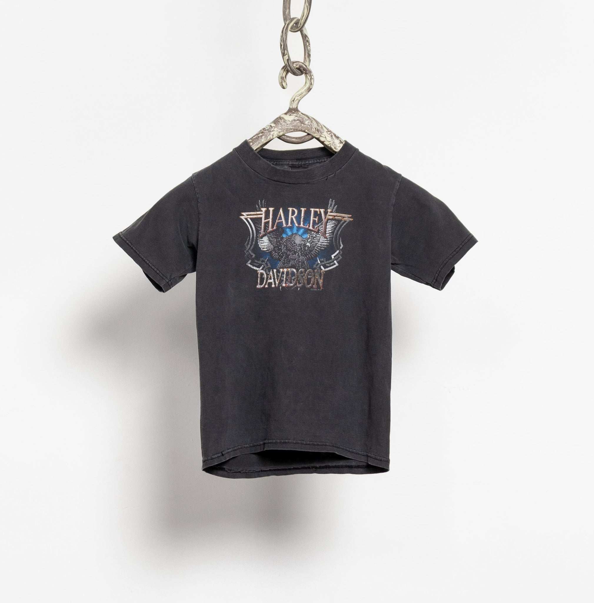 Black t-shirt with a logo on a hanger against a white background