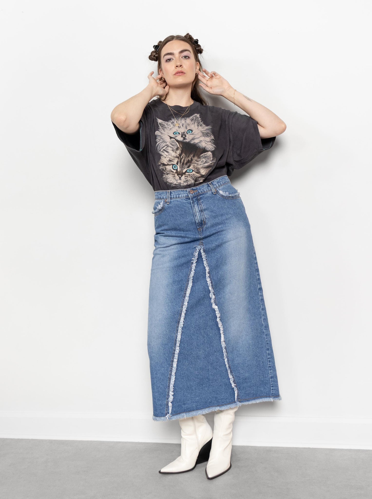 Person wearing a graphic t-shirt and denim skirt against a white background
