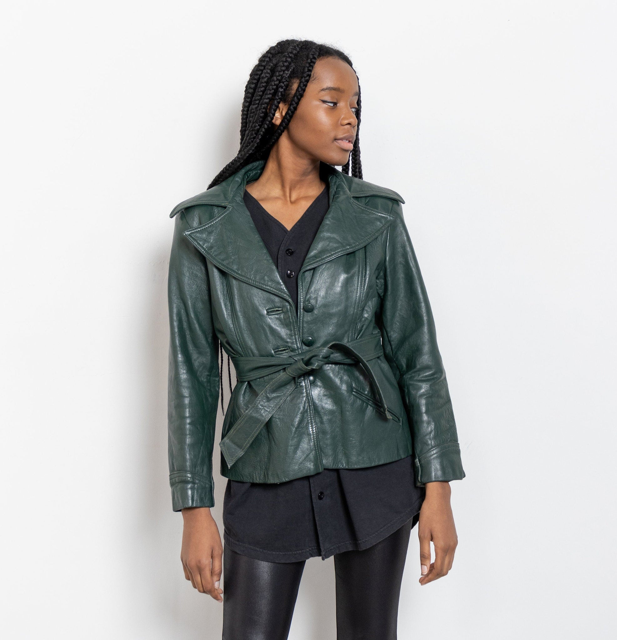 Woman wearing a green leather jacket on a white background