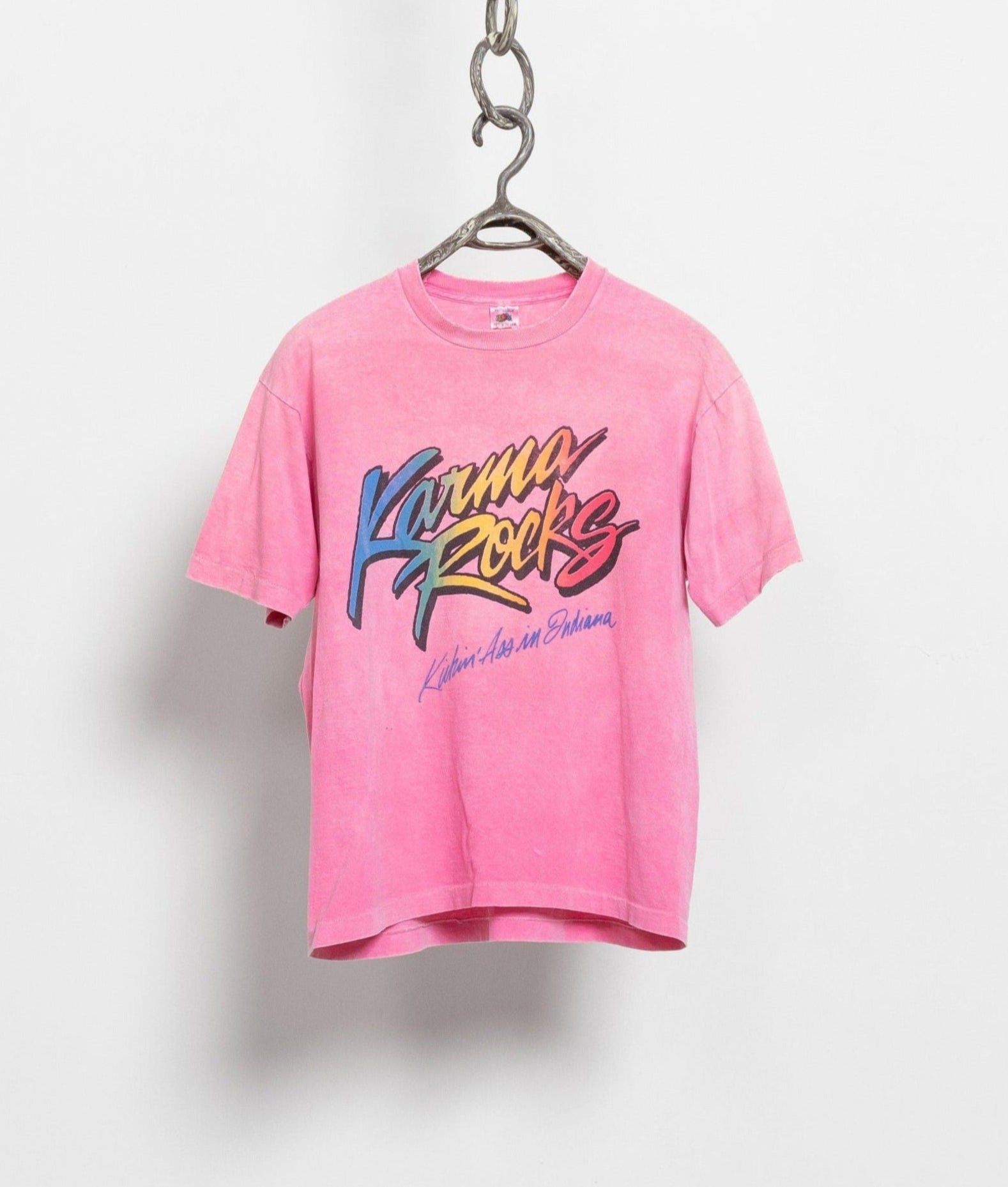 A vintage 80's hot pink t-shirt with the text 'Karma Rocks' printed on the front, displayed on a hanger against a white background.