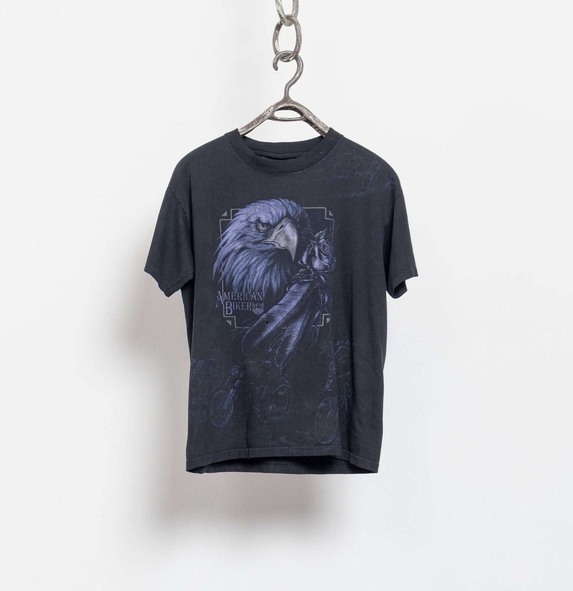 Black t-shirt with an eagle graphic on a hanger against a white background