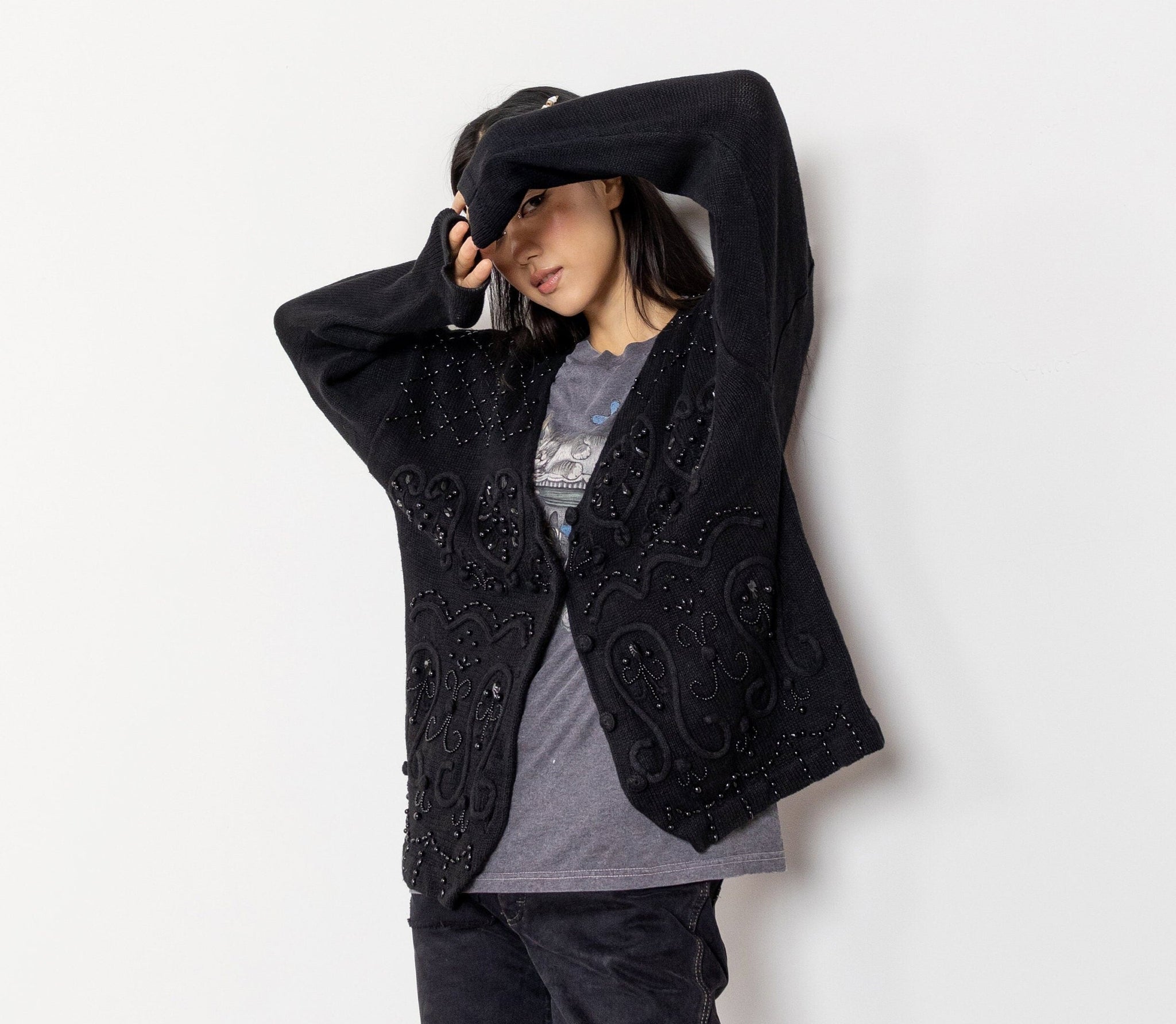 Person wearing a black embroidered jacket on a white background