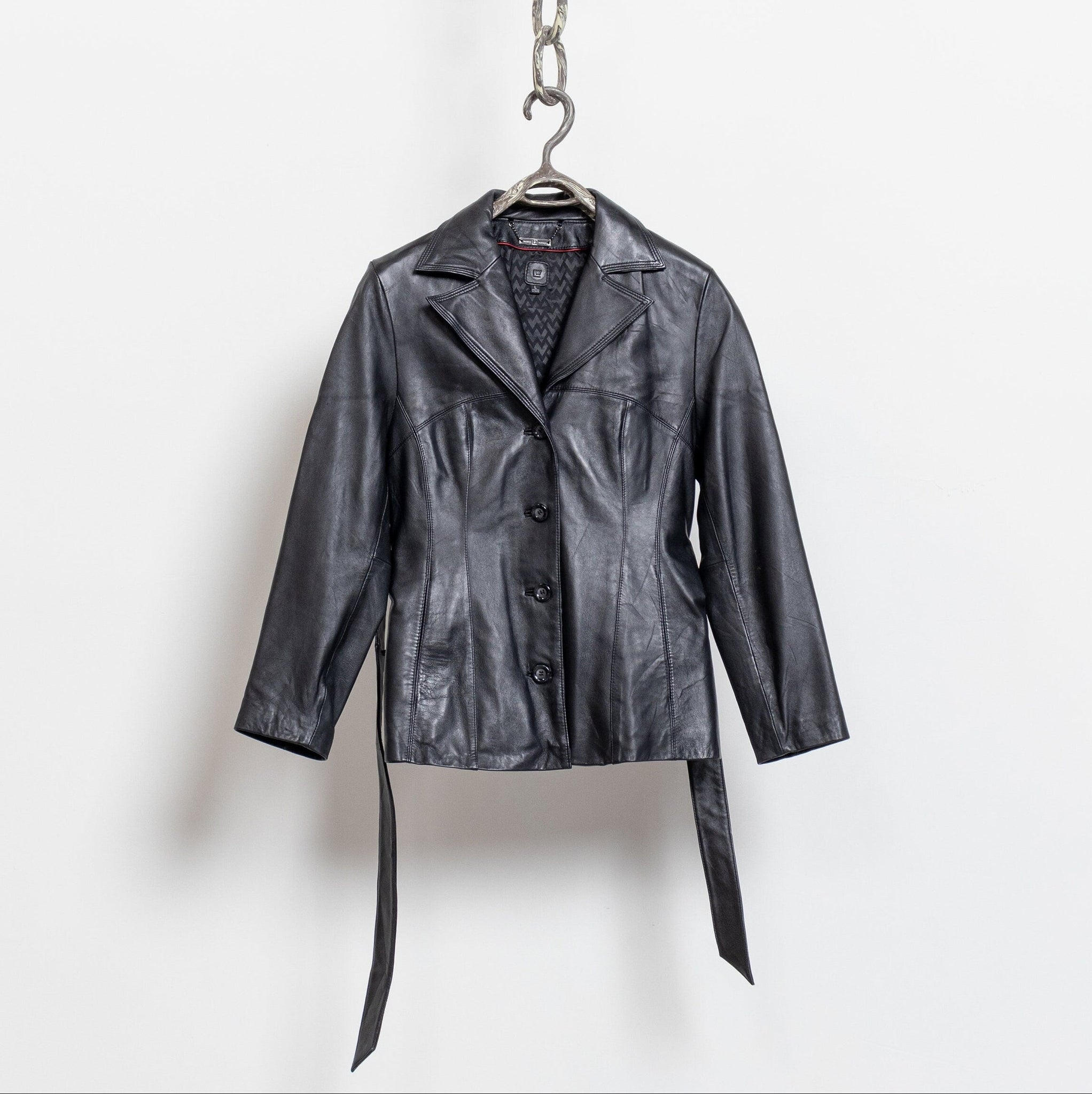 Black leather jacket hanging on a white background