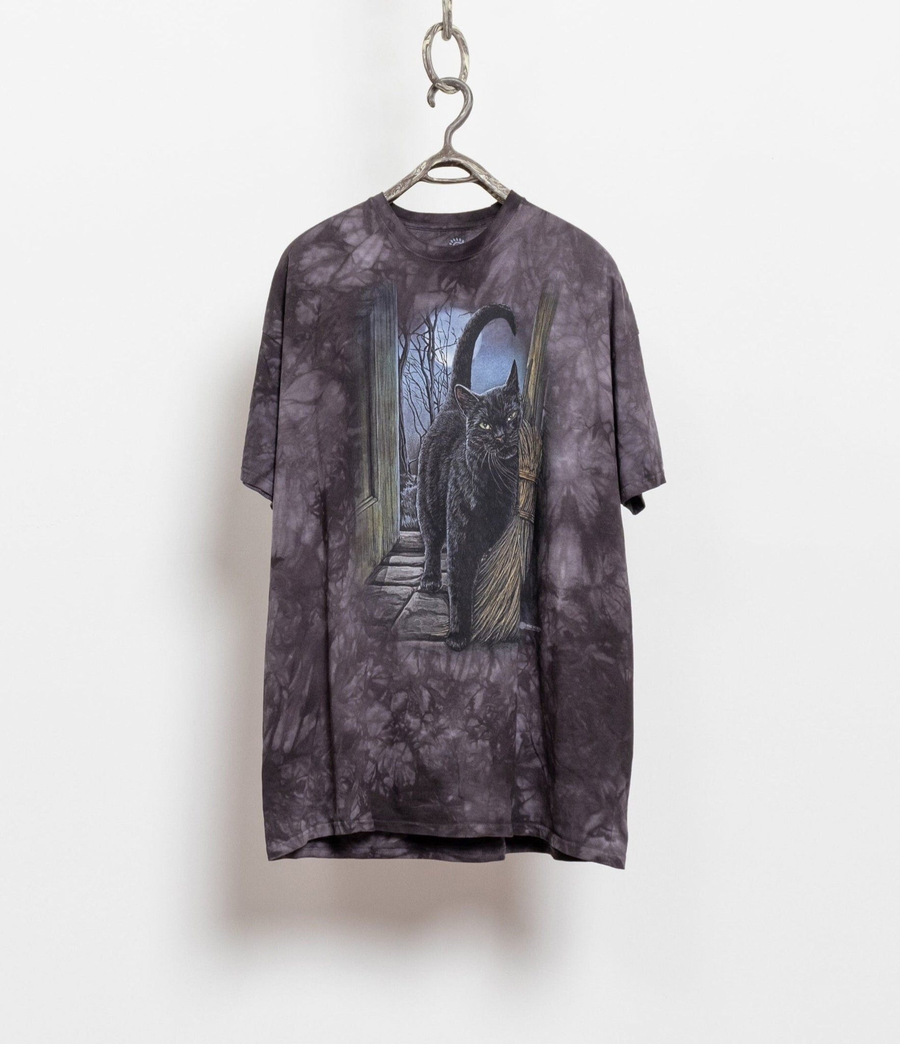 A vintage tie-dye cotton t-shirt with a graphic of a green-eyed black cat and a straw broom against a dark background.
