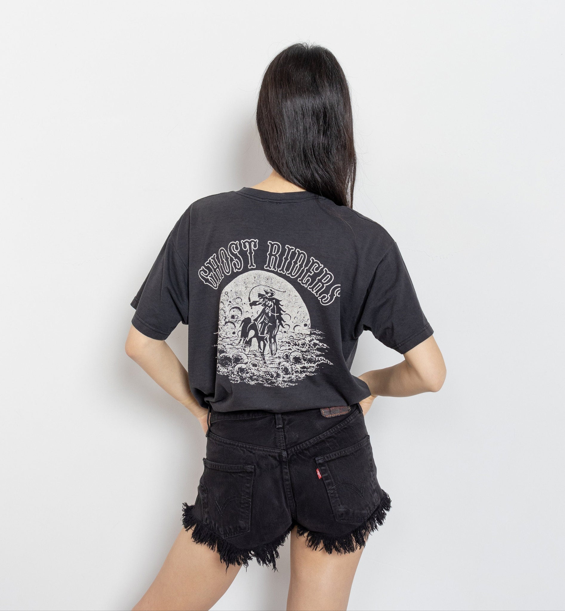 Person wearing a black t-shirt with a graphic design on the back.