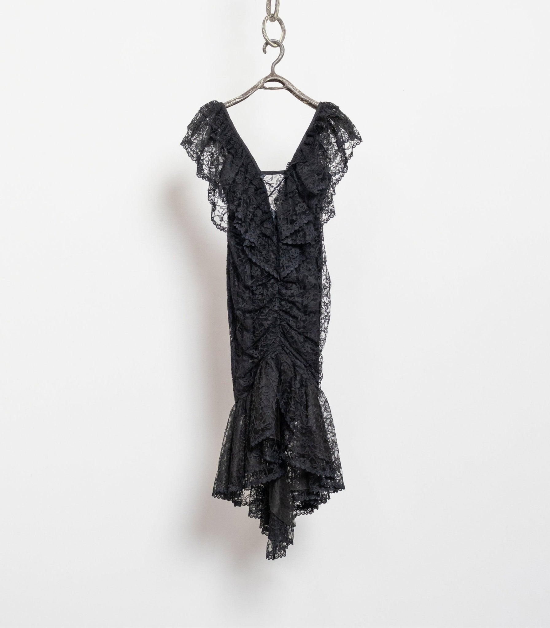 Black lace dress on a hanger against a white background