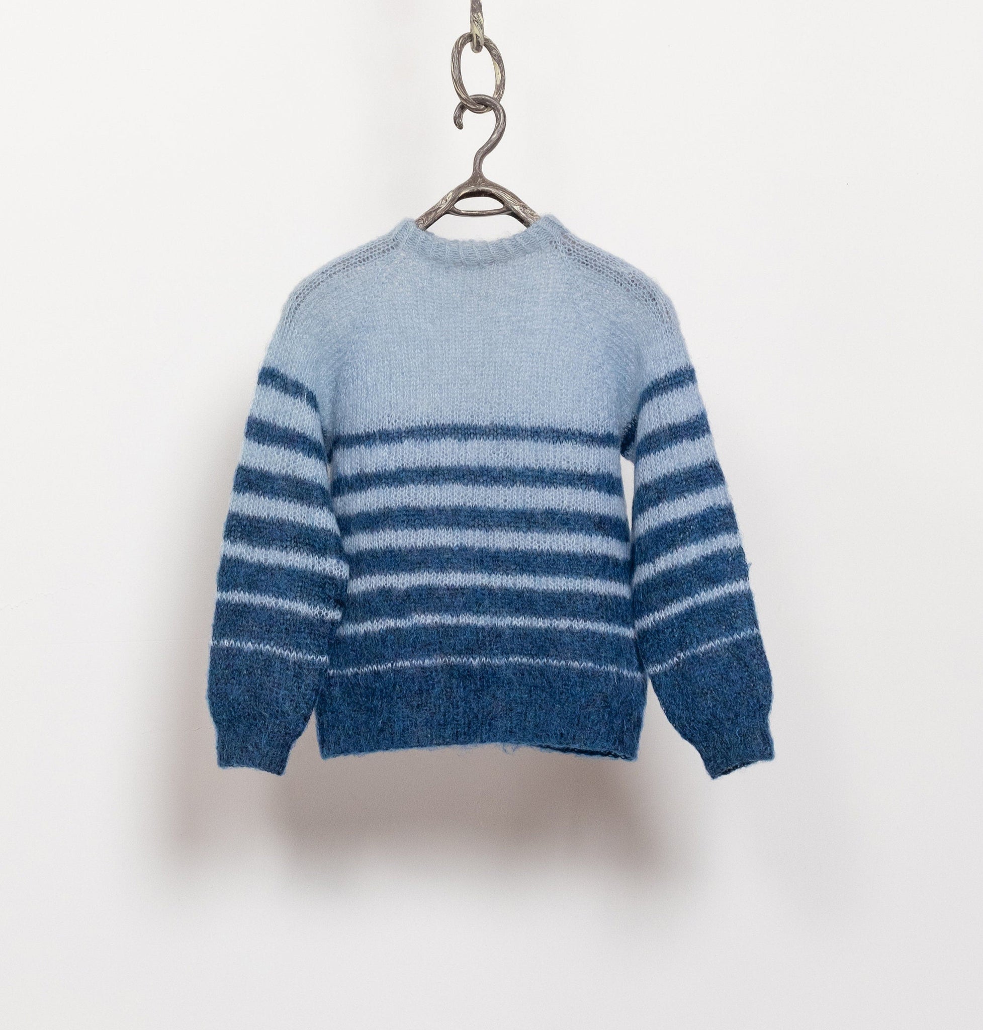 Blue striped sweater hanging on a white background